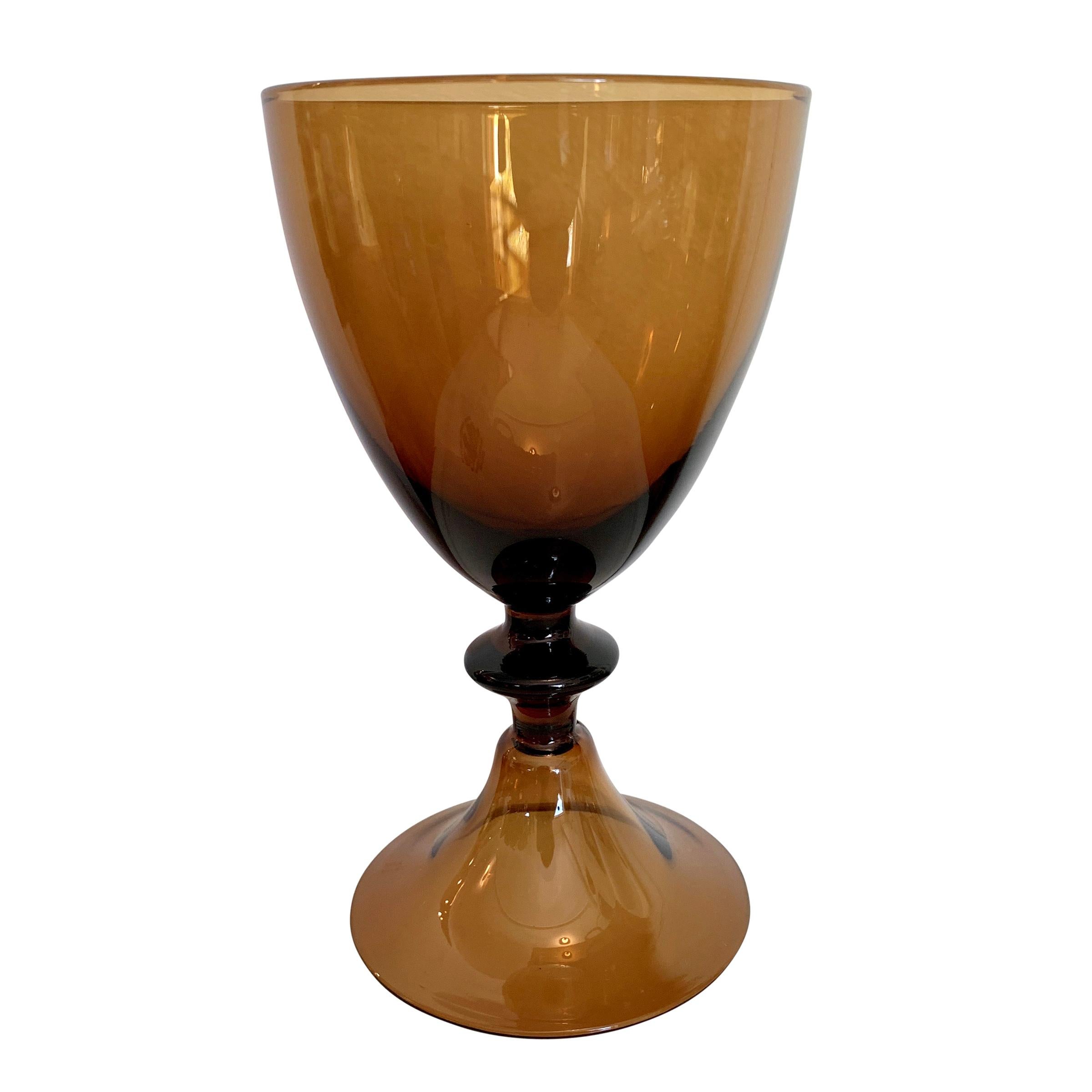 A set of eight Diane von Fürstenberg designed hand blown amber colored wine glasses with a gorgeous curvy shape and hollow feet. Marked 