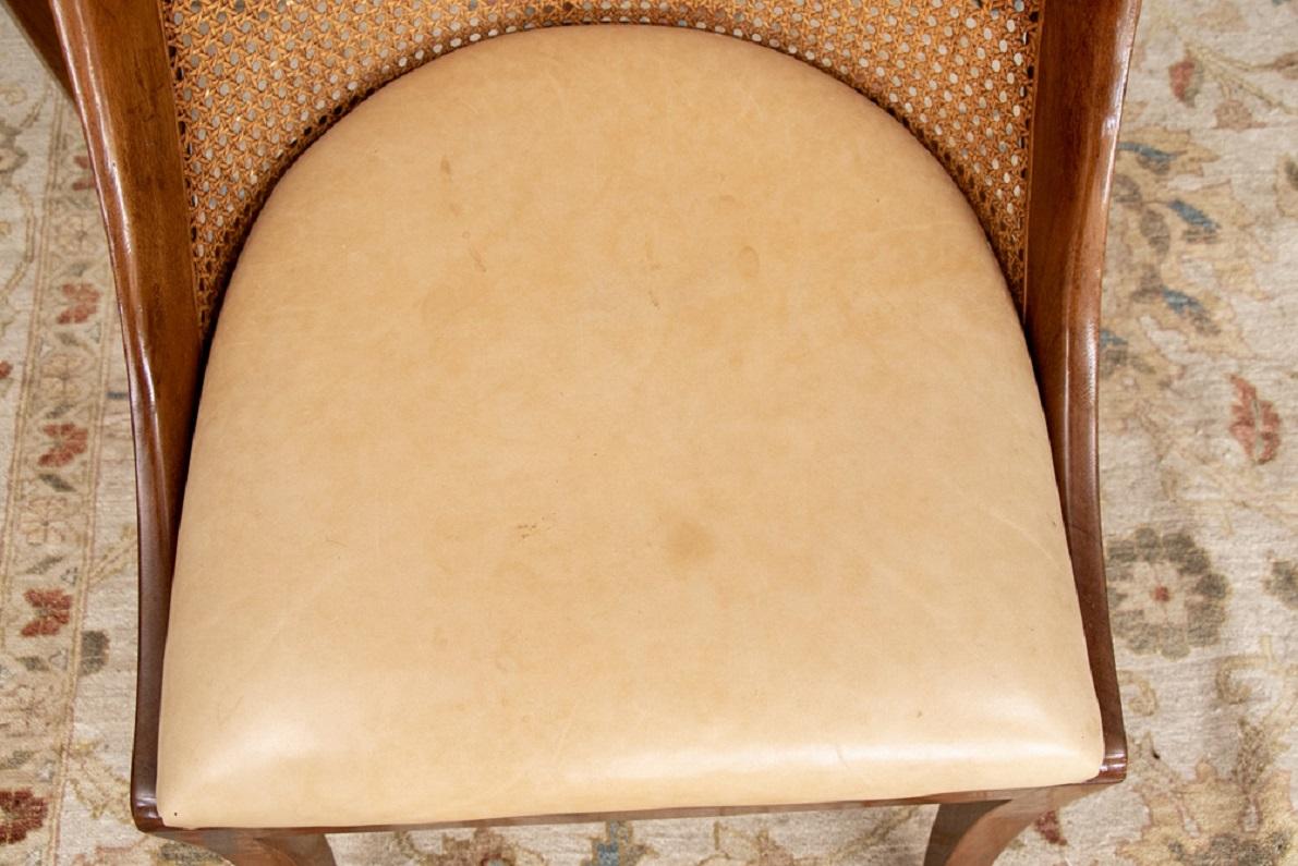 An extraordinary set of eight dining chairs. Tub shaped walnut side chairs with caned backs, raised on splayed legs front and back. 
Pale leather upholstered seats. Very comfortable.

Condition: Good condition with minor expected signs of use