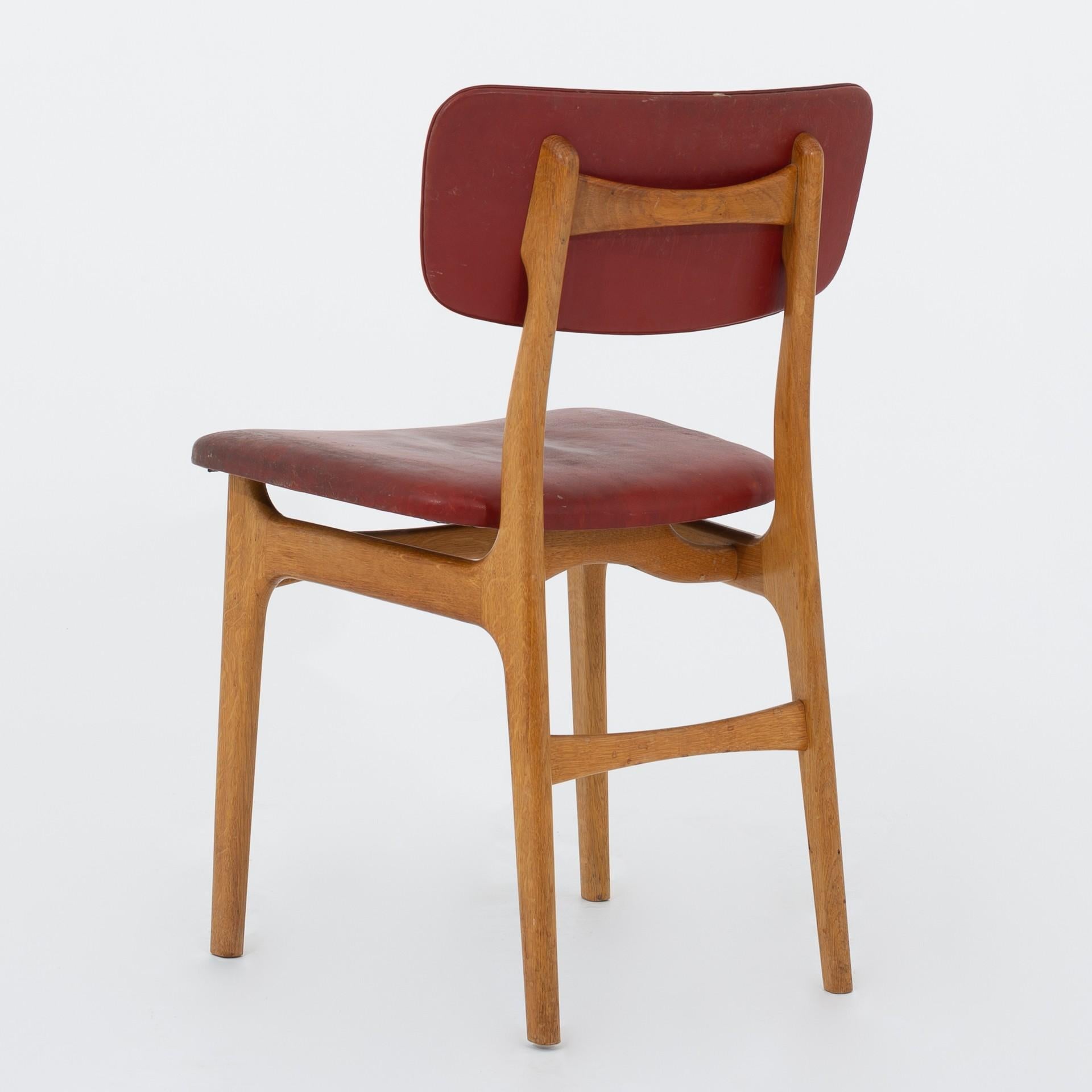 Eight dining chairs in oak and patinated red leather. Maker Gustav Bertelsen.
