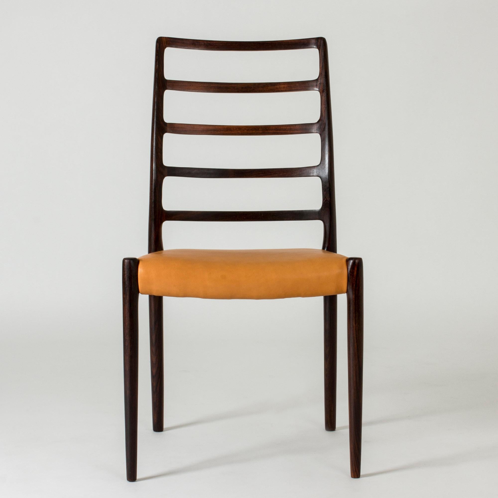 Set di otto straordinarie sedie da pranzo di Niels O. Møller. Realizzato in legno splendidamente scolpito con giunture senza giunture. La venatura del legno segue le linee degli schienali alti. Sedili in pelle naturale di qualità.