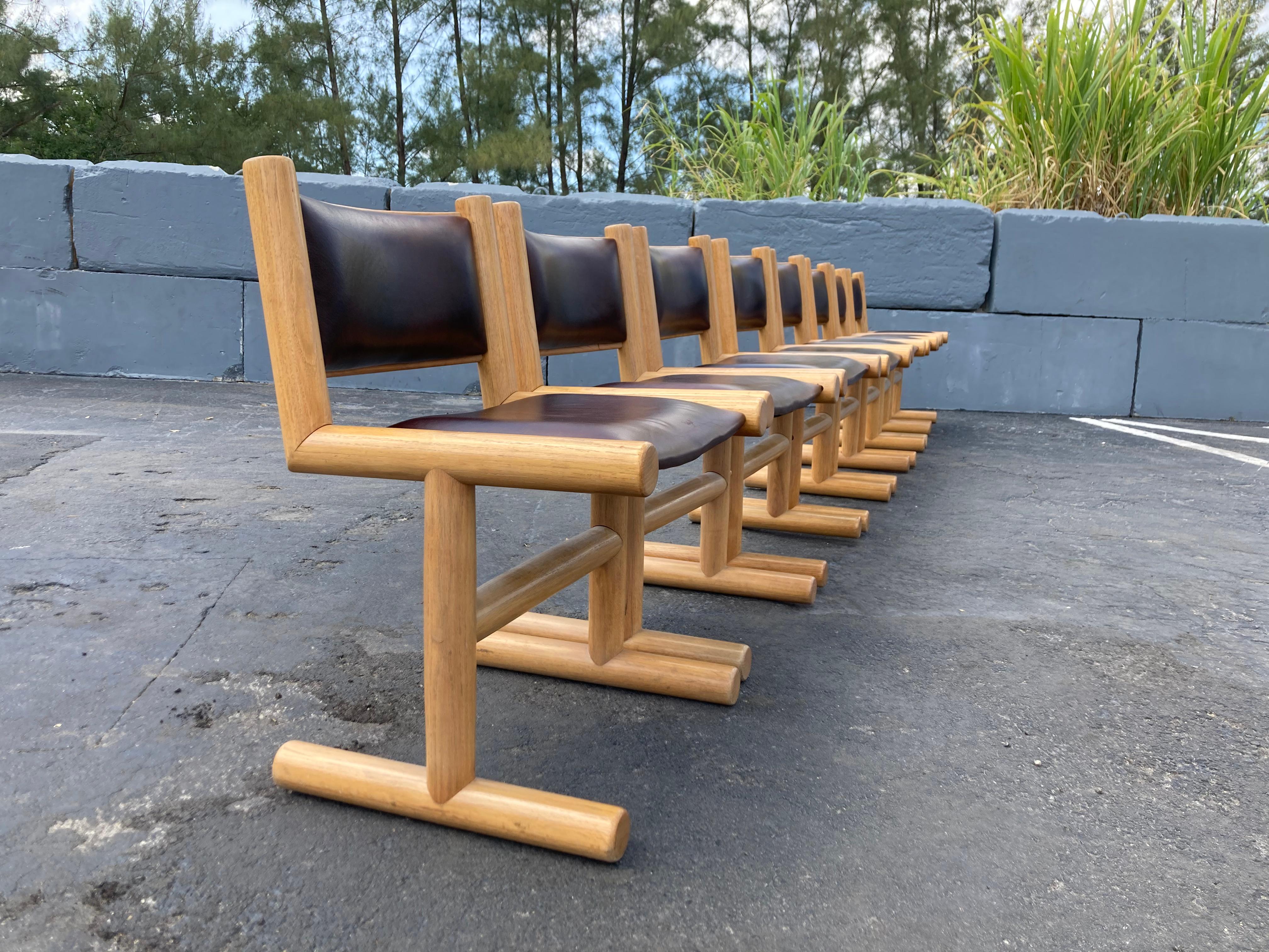 Set of eight unique oak and leather dining chairs.