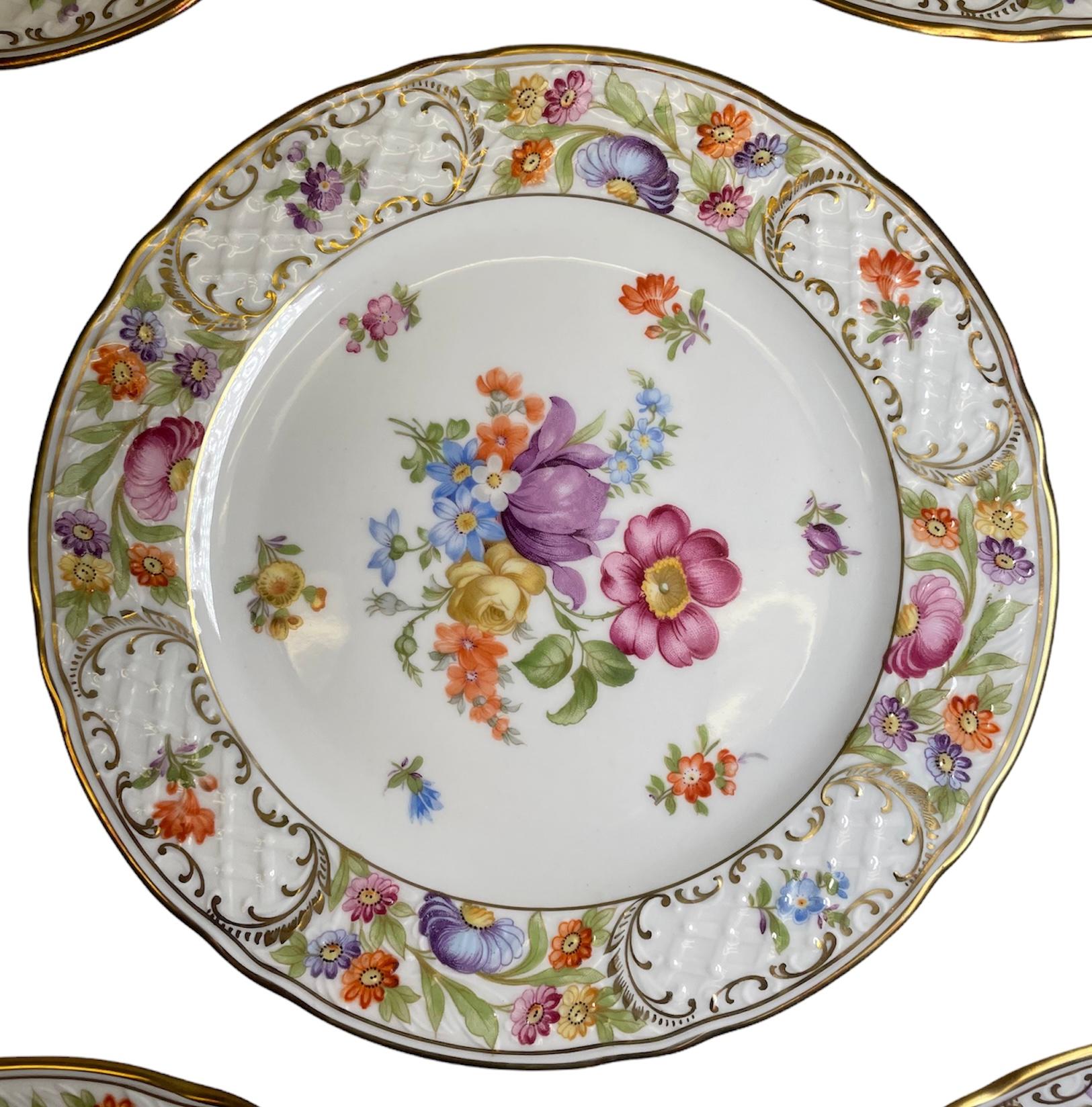 This is a set of eight Schumann porcelain salad plates. They depict a white background with a hand painted bouquet of flowers in the center. Also the trellis porcelain rim is adorned with bouquets of flowers alternated with single branches of