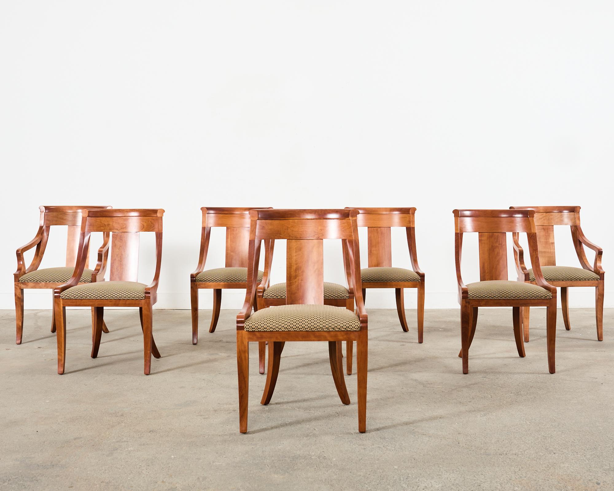 Fabulous set of eight gondola dining chairs by Baker crafted in the empire taste. The frames feature a gracefully curved scoop or spoon back constructed from radiant fruitwood. The set consists of six side chairs and two host armchairs with 23 inch