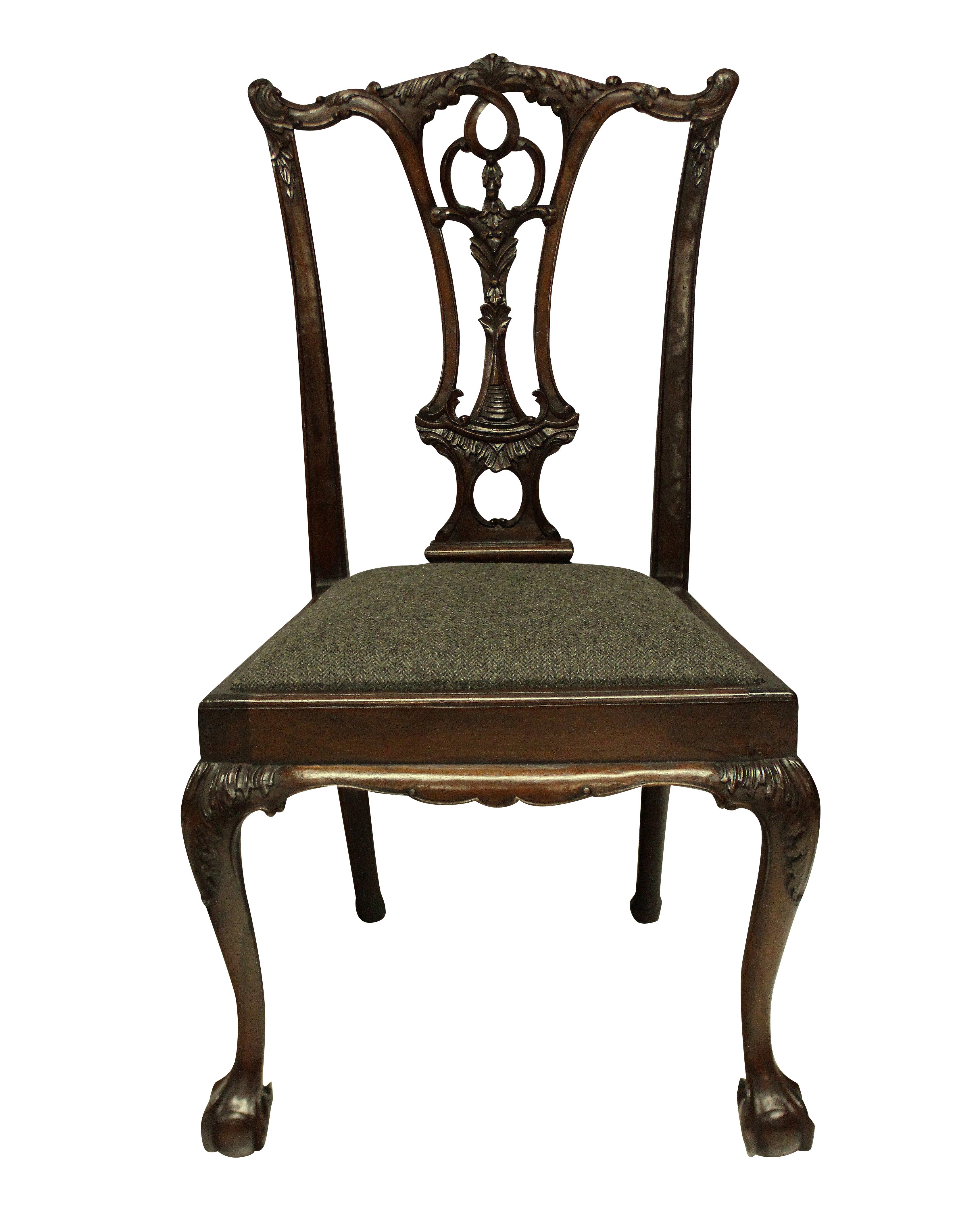 A set of eight English, carved mahogany Chippendale style dining chairs, comprising six chairs and two carvers. Beautifully carved and with herringbone tweed seats.