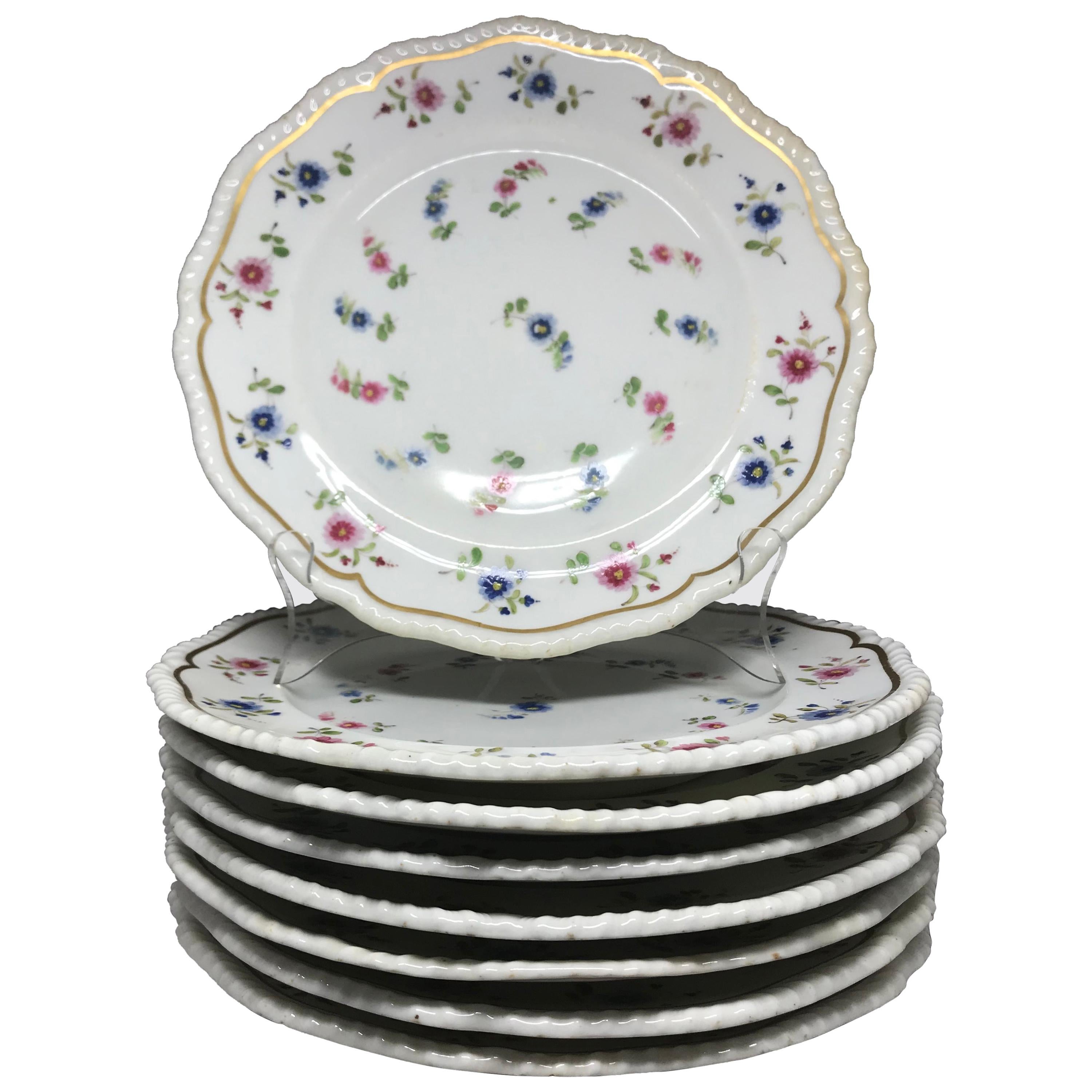 Ensemble de huit assiettes à fleurs bleues et roses. Plaques à bandeau et dorées avec des fleurs bleues et roses, avec marquage 