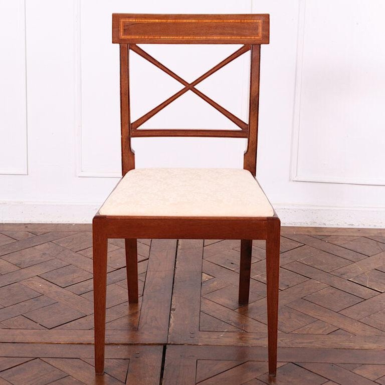 Set of eight English inlaid mahogany Sheraton style dining chairs of simple form, the square backs with ‘X’ splat and inlaid banded top rails.



  
