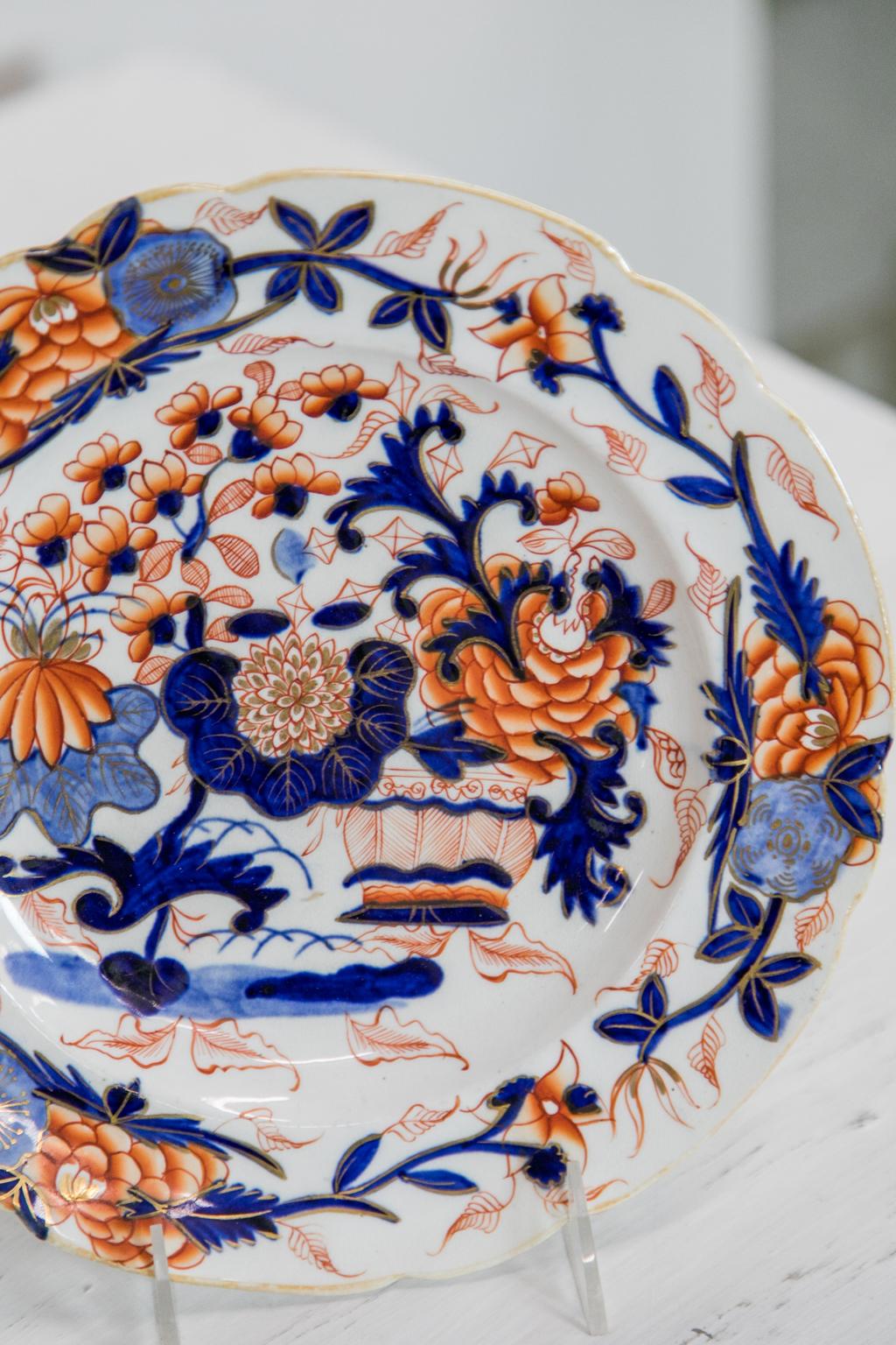 This set of eight Staffordshire plates are decorated with stylized flowers, leaves, and urns. There are gilt highlights that have wear in some areas. There are no markings, but the style of decoration, type of glaze, body composition, and elements