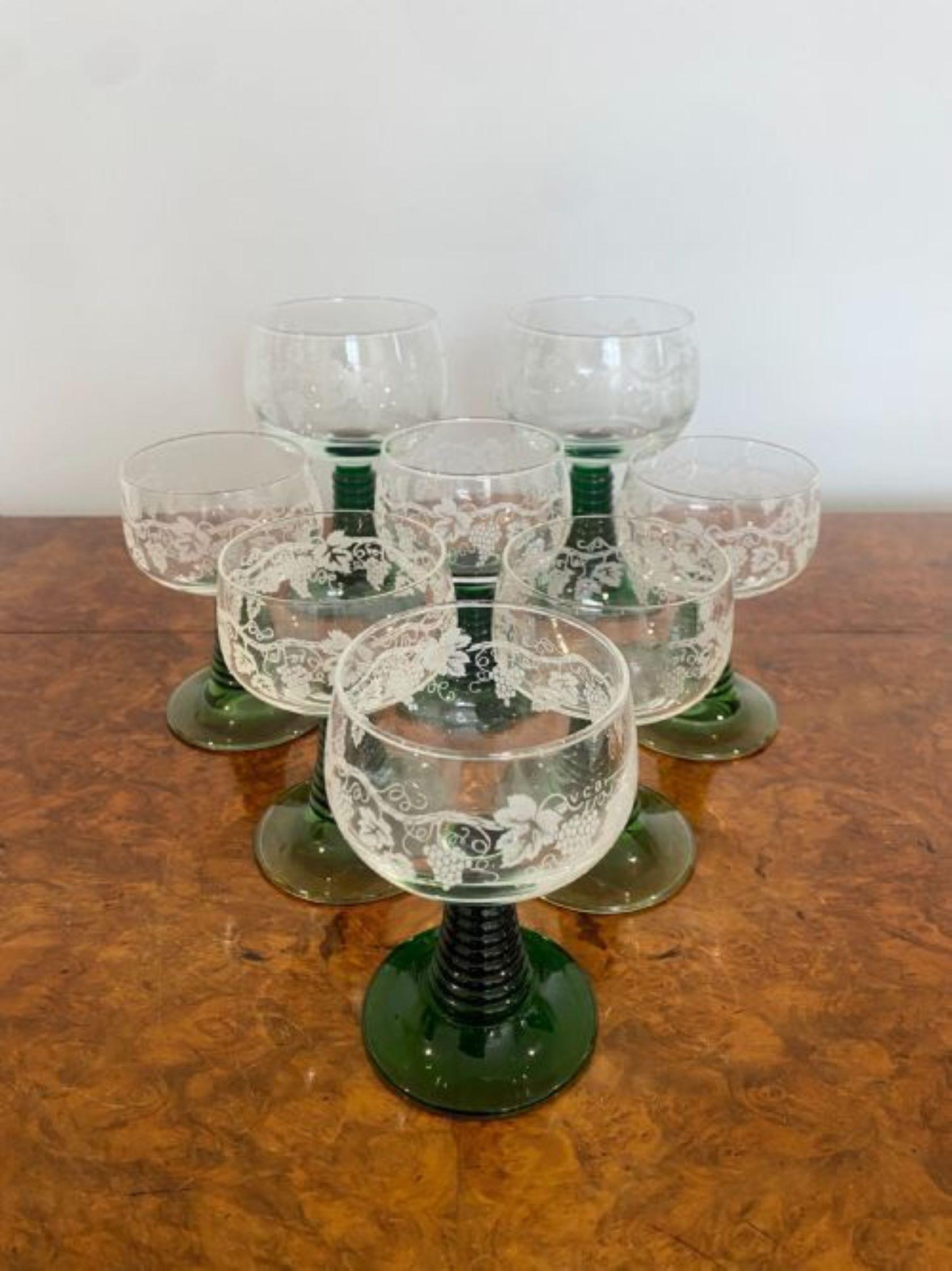 Set of eight engraved antique wine glasses having a quality shaped with glass engraved with grapes on a green ribbed circular base