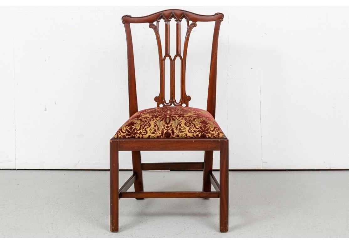 A particularly elegant and finely crafted set of chairs by Stuart Swan of Wellesley, Massachusetts. With two arm and six side chairs. The finely carved splats with open arch motifs flanked by leaves and ending in scrolls. The high cushioned seats
