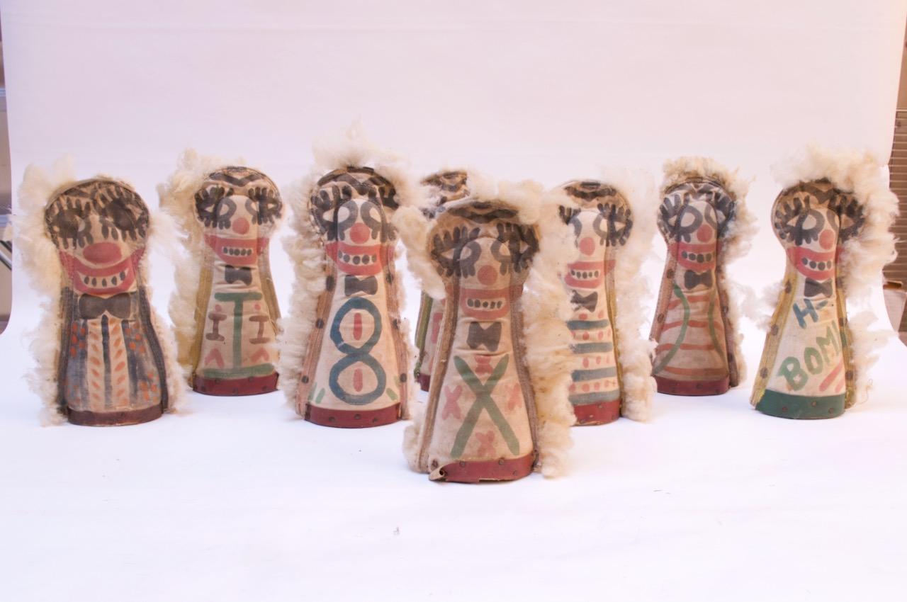 Folk Art carnival punks / knockdown dolls composed of canvas forms lined with cotton fur supported by carved wood bases for added stability / weight, circa 1910. Whimsical double sided illustrations and, in some cases, text identify each respective