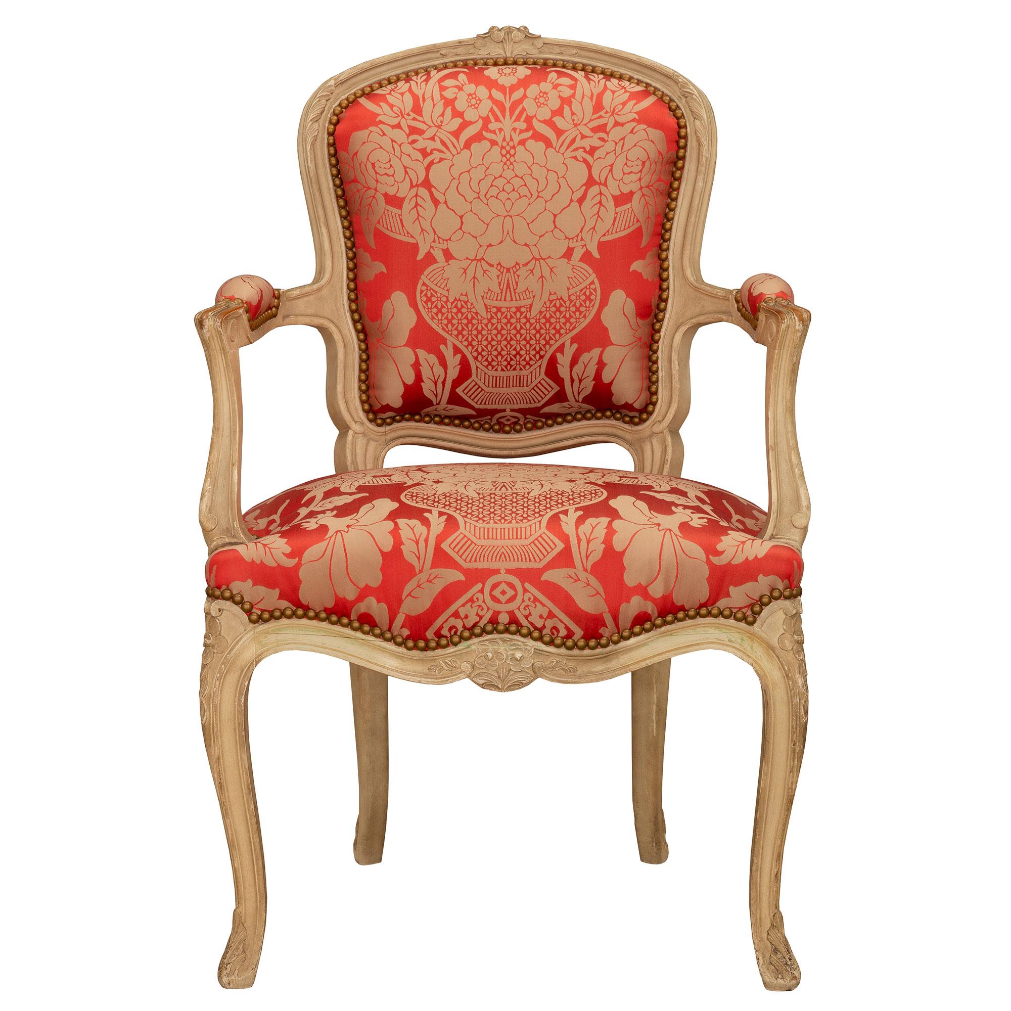 A most elegant and complete set of eight French 19th century Louis XV st. patinated wood dining chairs. Each country French dining chair is raised by fine cabriole legs with a lovely mottled design, carved acanthus leaves and charming rosettes. The