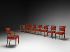 Lot de huit fauteuils Art déco français en bois et similicuir rouge