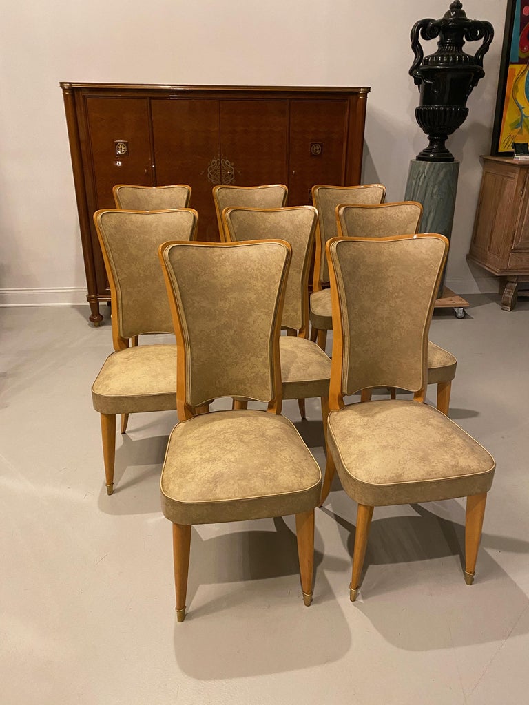 Set of eight French Art Deco dining chairs in blond wood. The chairs frames have been refinished, while the fabric is still original.