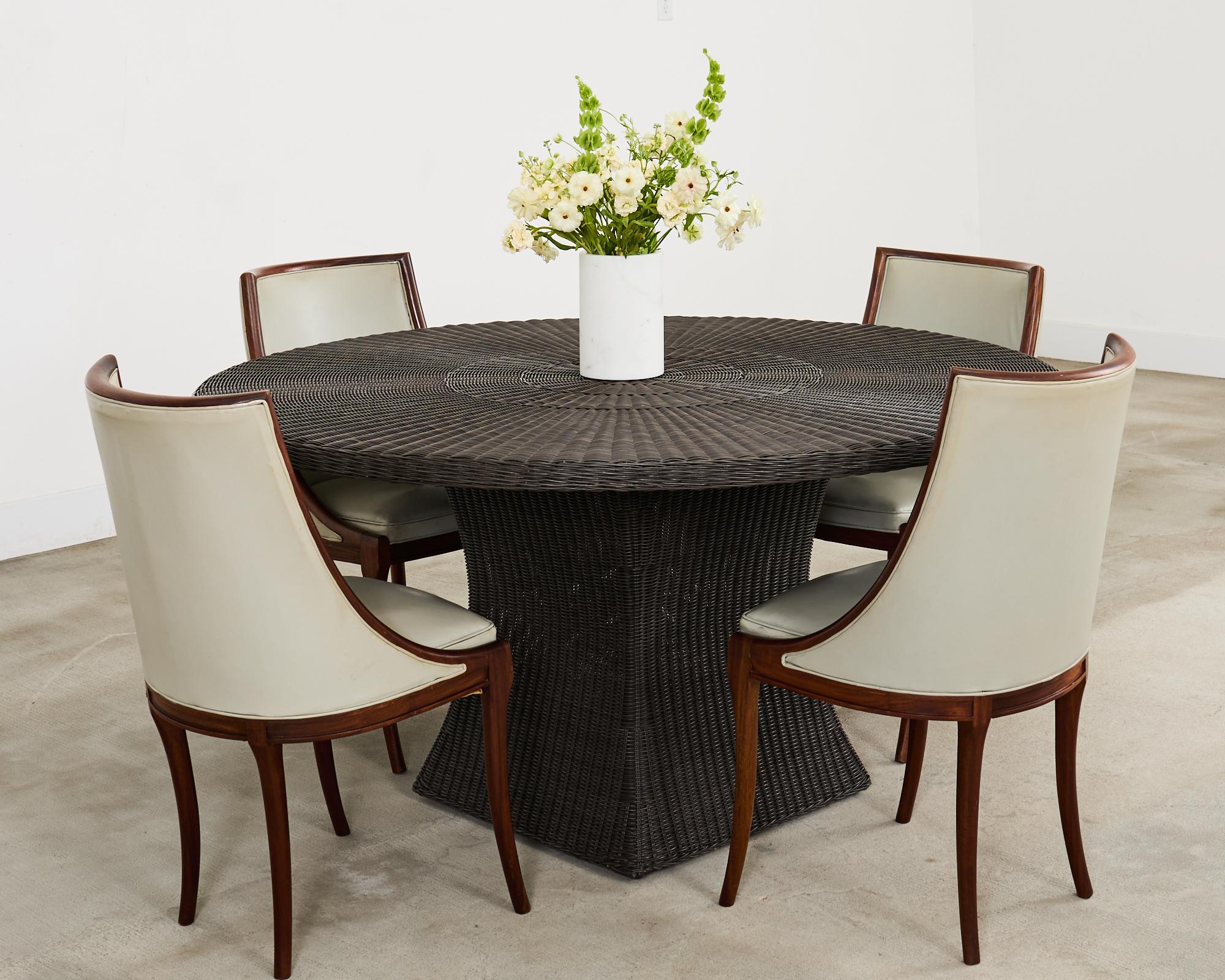 Distinctive set of eight French gondola dining chairs crafted from mahogany. The art deco style chairs have a round barrel-shaped back with gracefully curved sides. The frames are upholstered with a light oyster colored faux leather naugahyde. The