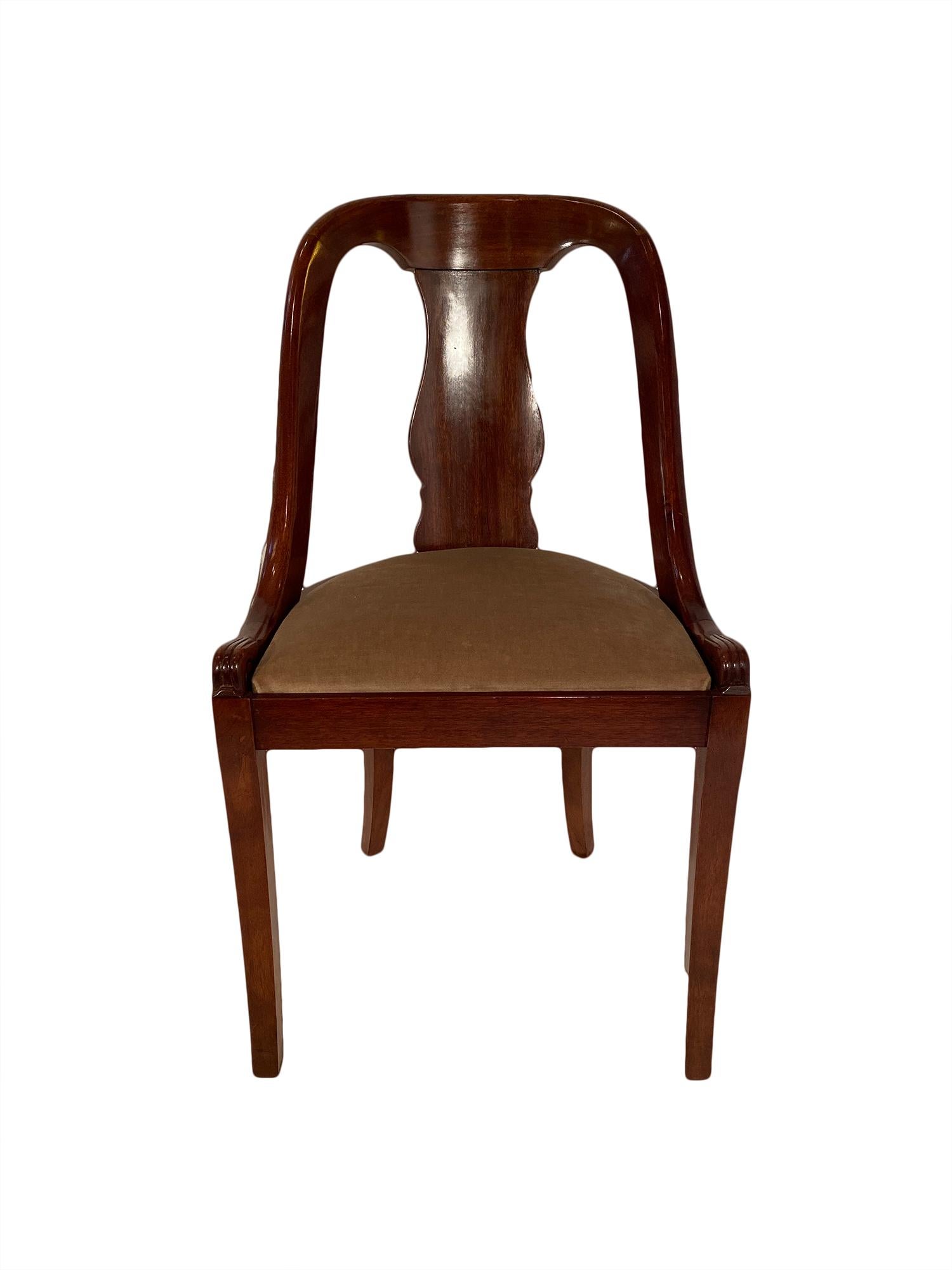 Set of eight French Empire gondola chairs made of solid mahogany and featuring sabre back legs, console front legs. We love the solidity of this set and the classic silhouette.