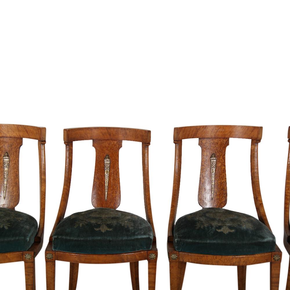A set of eight ( four shown ) French Empire style Amboyna wood ‘Gondola’ chairs, the curved backs featuring gilt bronze torches, the legs with gilt bronze feet. The original 'drop-in' seats retain their original mohair with Empire design- if