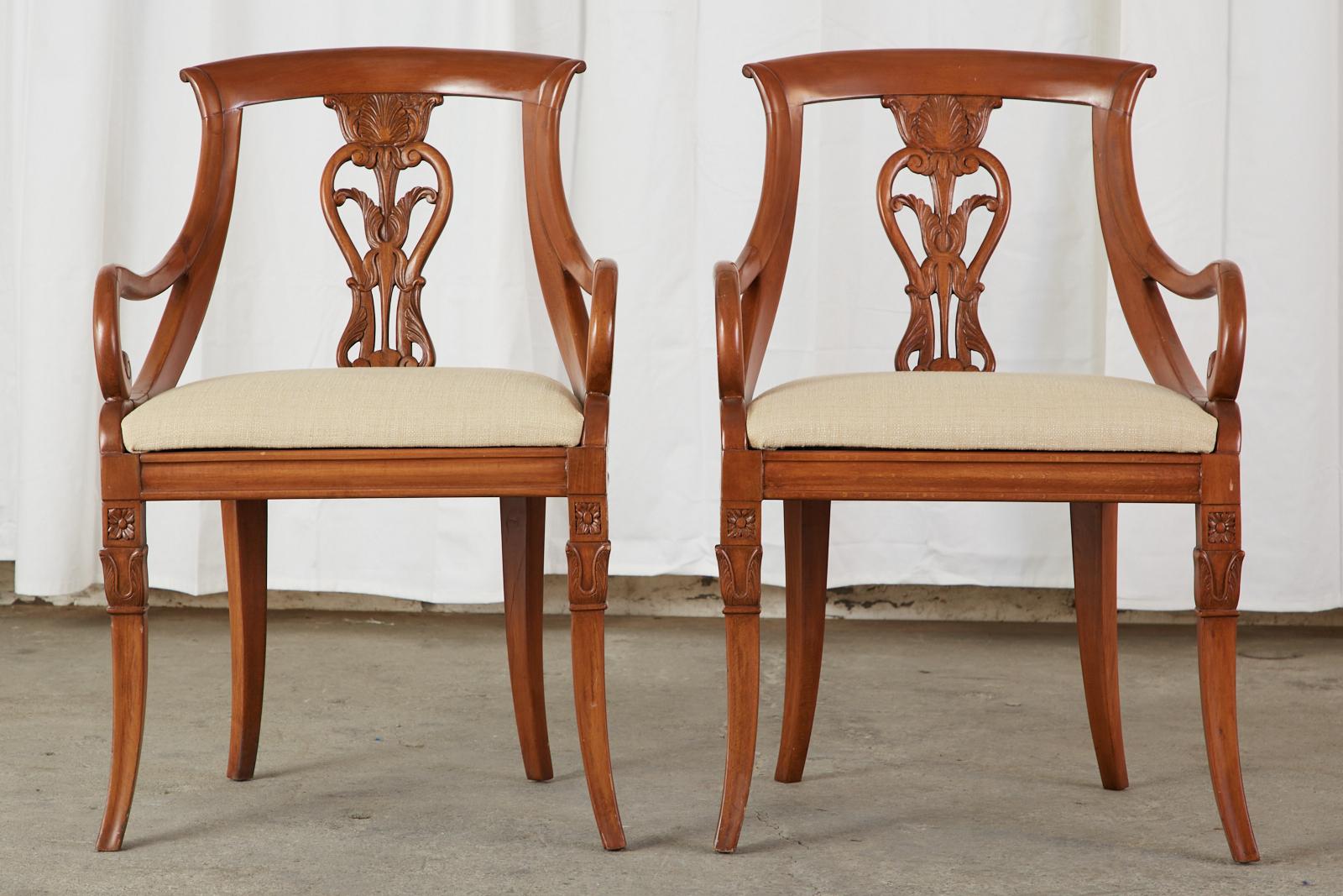 Magnificent set of eight French gondola style dining chairs crafted in the neoclassical empire taste. The gracefully curved frames are carved from fruitwood having a decorative foliate acanthus motif back splat. The set consists of six side chairs