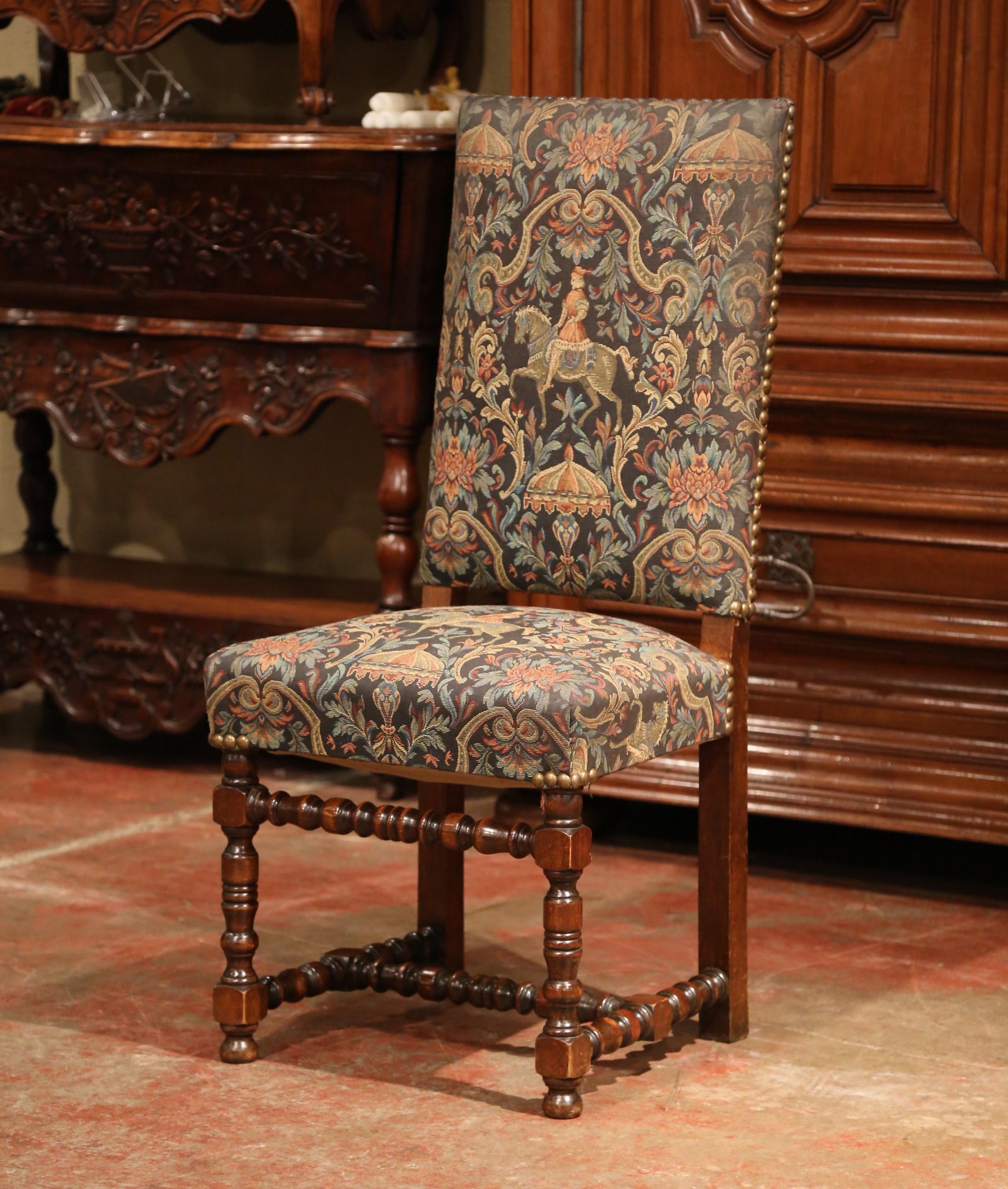Crafted in France, circa 1960, the Louis XIII style chairs feature nicely turned legs with bottom stretcher, a high back and a wide seat for comfort. Each piece is upholstered with a machine made tapestry in the traditional Cluny style. The chair