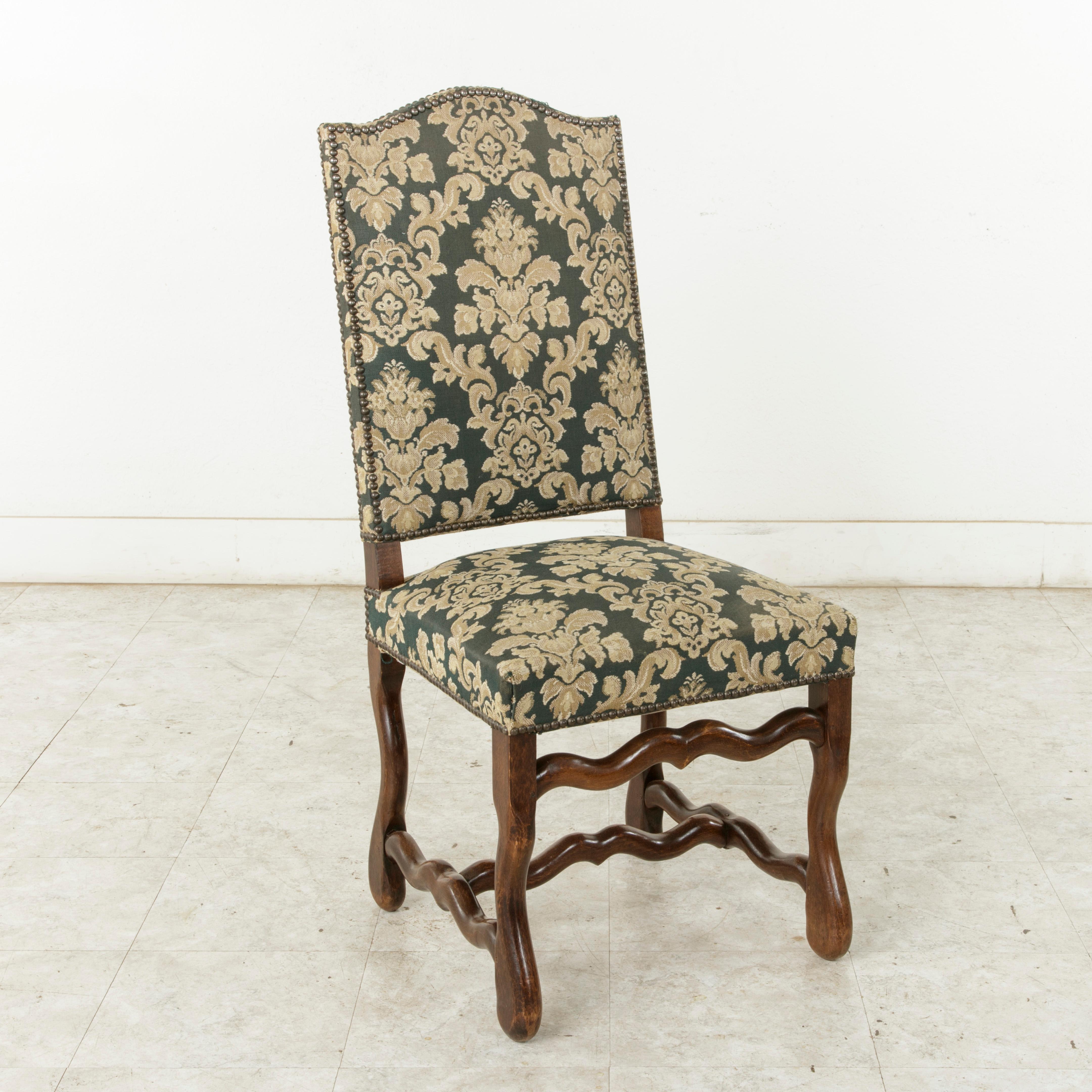 This set of eight French ash mutton leg side chairs or dining chairs from the mid-20th century are of hand pegged construction. These tall dining chairs with arched backs are upholstered in a green tapestry and finished with nailhead trim. The