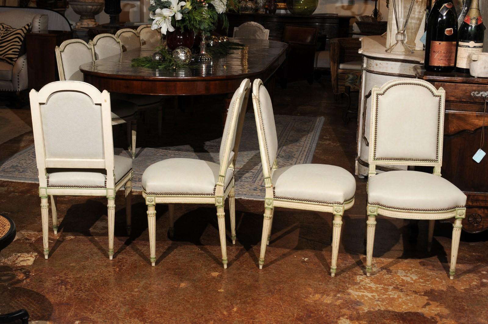 A set of eight French Louis XVI style dining room side chairs from the 19th century, with new upholstery and fluted legs. Born in France during the politically dynamic 19th century, each of this set of eight side chairs features a slightly slanted