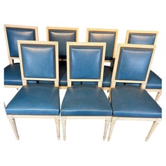 Lot de huit chaises de salle à manger de style Louis XVI, peintes en blanc et garnies de cuir bleu