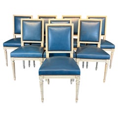 Lot de huit chaises de salle à manger de style Louis XVI, peintes en blanc et garnies de cuir bleu