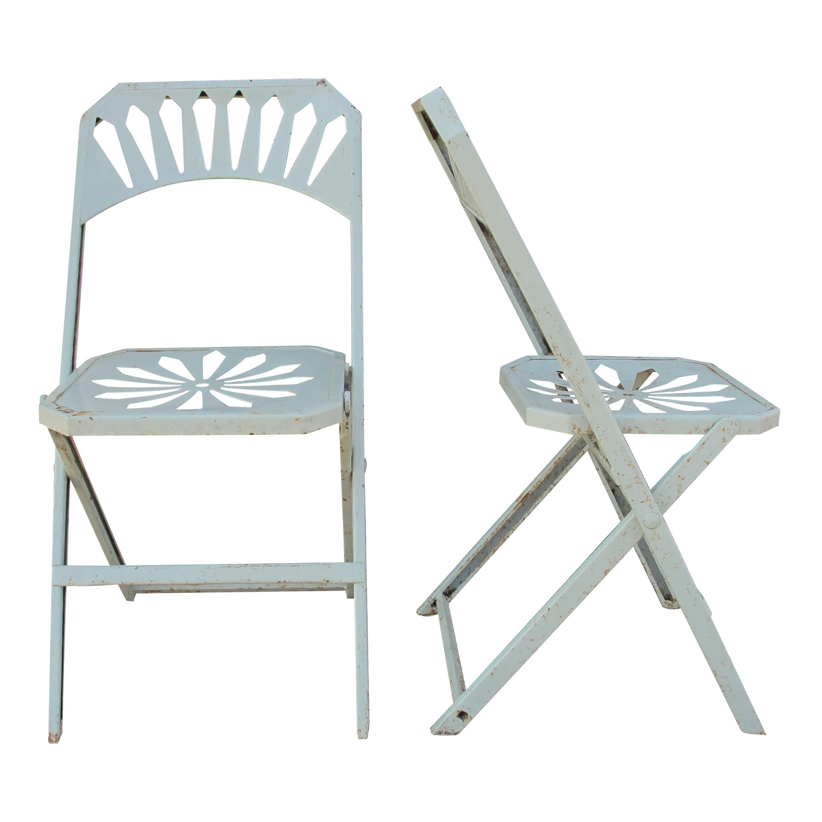 Questo affascinante set di otto sedie da giardino francesi vintage degli anni '50 presenta un classico design pieghevole. Realizzate in metallo, queste sedie presentano un intricato motivo di intagli sulla seduta e un elegante dettaglio a raggiera
