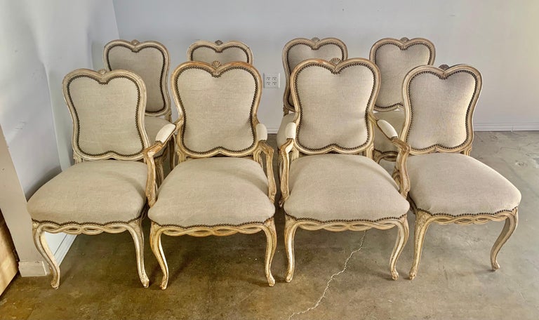 Set of eight French painted dining chairs. The chairs have a beautiful shape and intricate carved details. There is a heart shaped top. The chairs stand on four cabriole legs. There is a twisted rope detail around the perimeter of the chairs. The