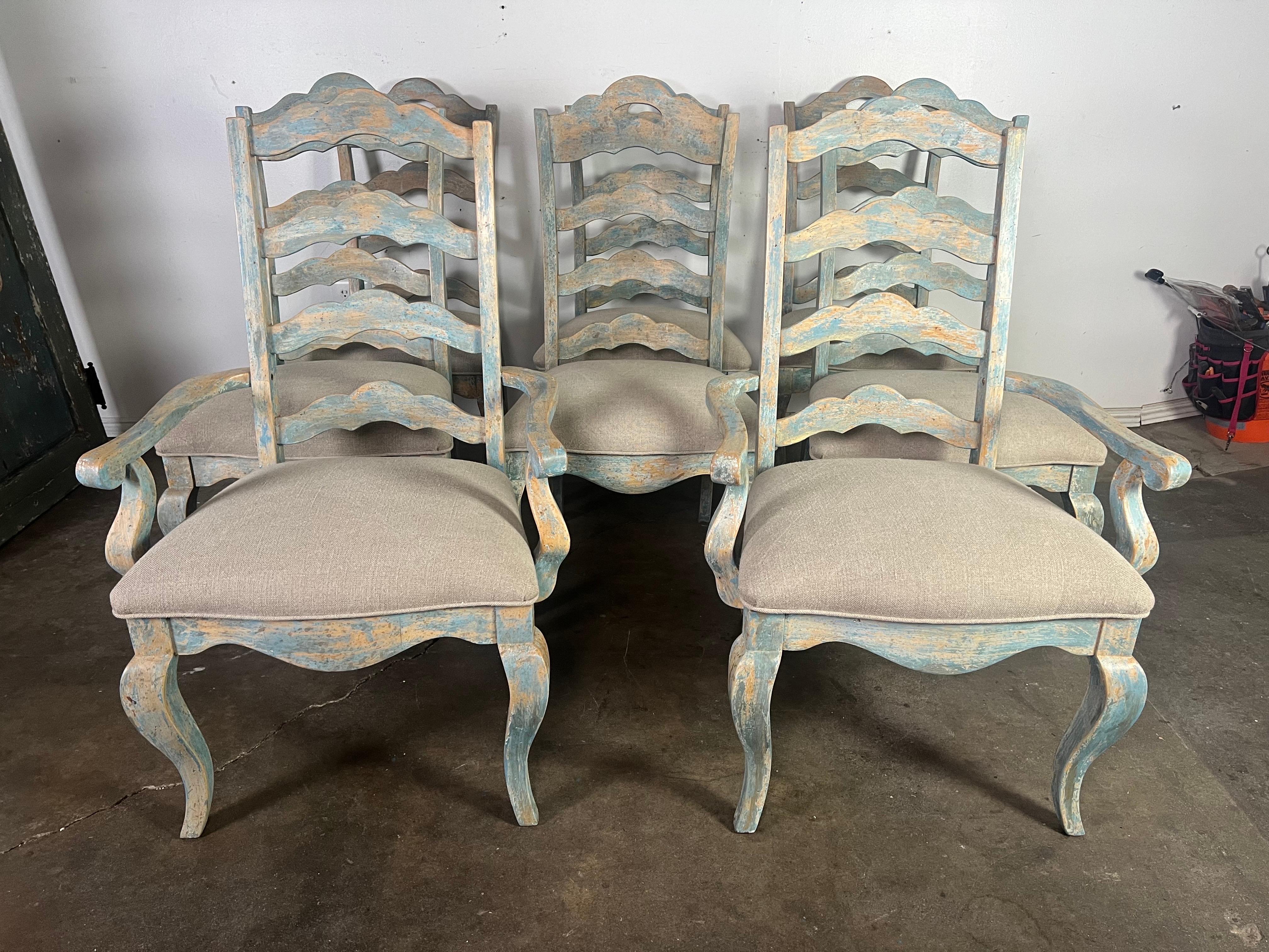 Ensemble de huit chaises de salle à manger peintes de style provincial français.  D'aspect rustique mais élégant, ces chaises présentent une finition vieillie avec une patine bleue qui leur confère un style plage-chic ou campagne française.  Les
