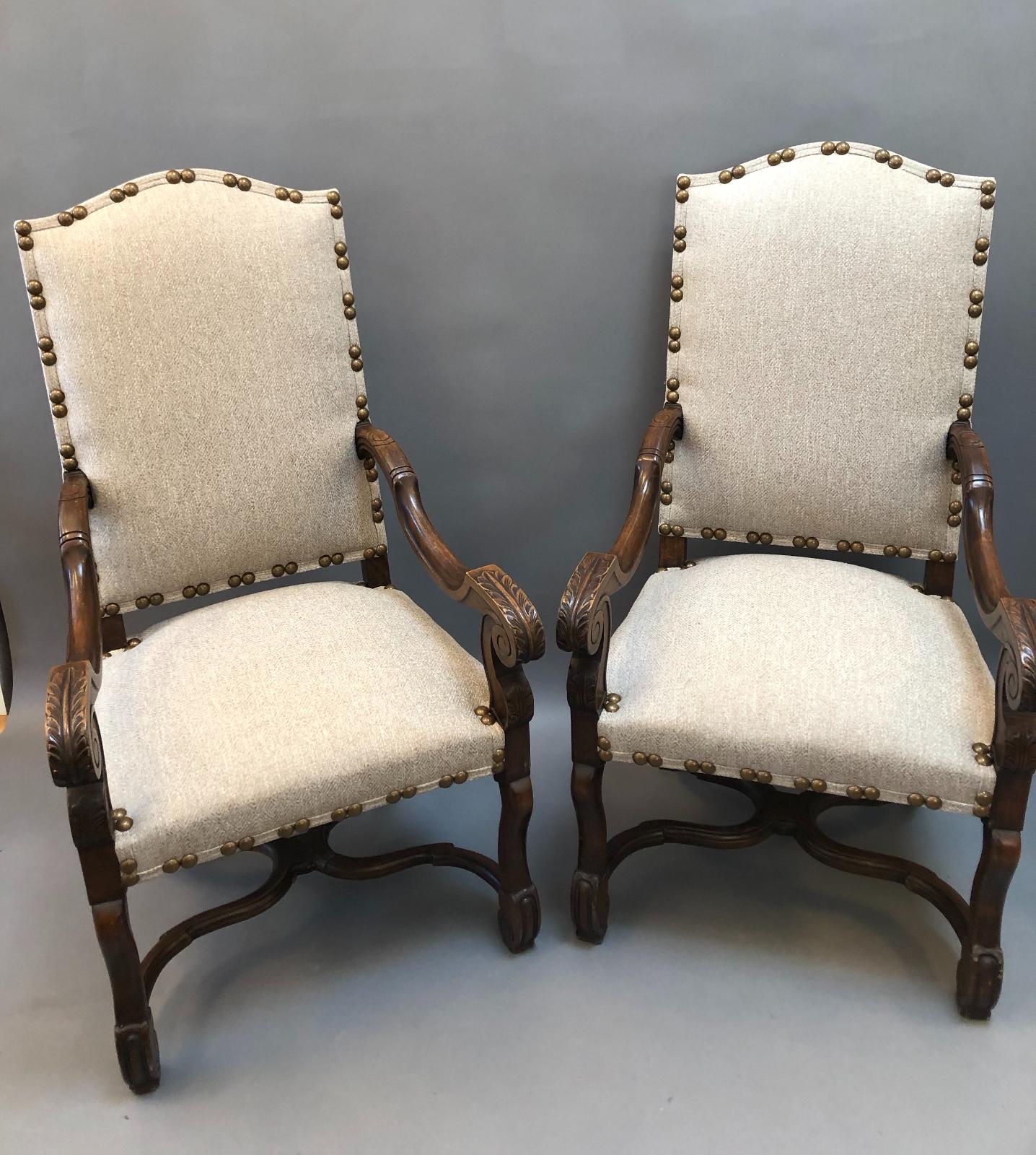 Set of Eight French Provincial Louis XIV Style Dining Chairs. Richly patinated walnut with carved “os de mouton” (mutton-bone) legs and stretchers. Two Armchairs and Six Side chairs, all recently reupholstered with nail head decoration. Great