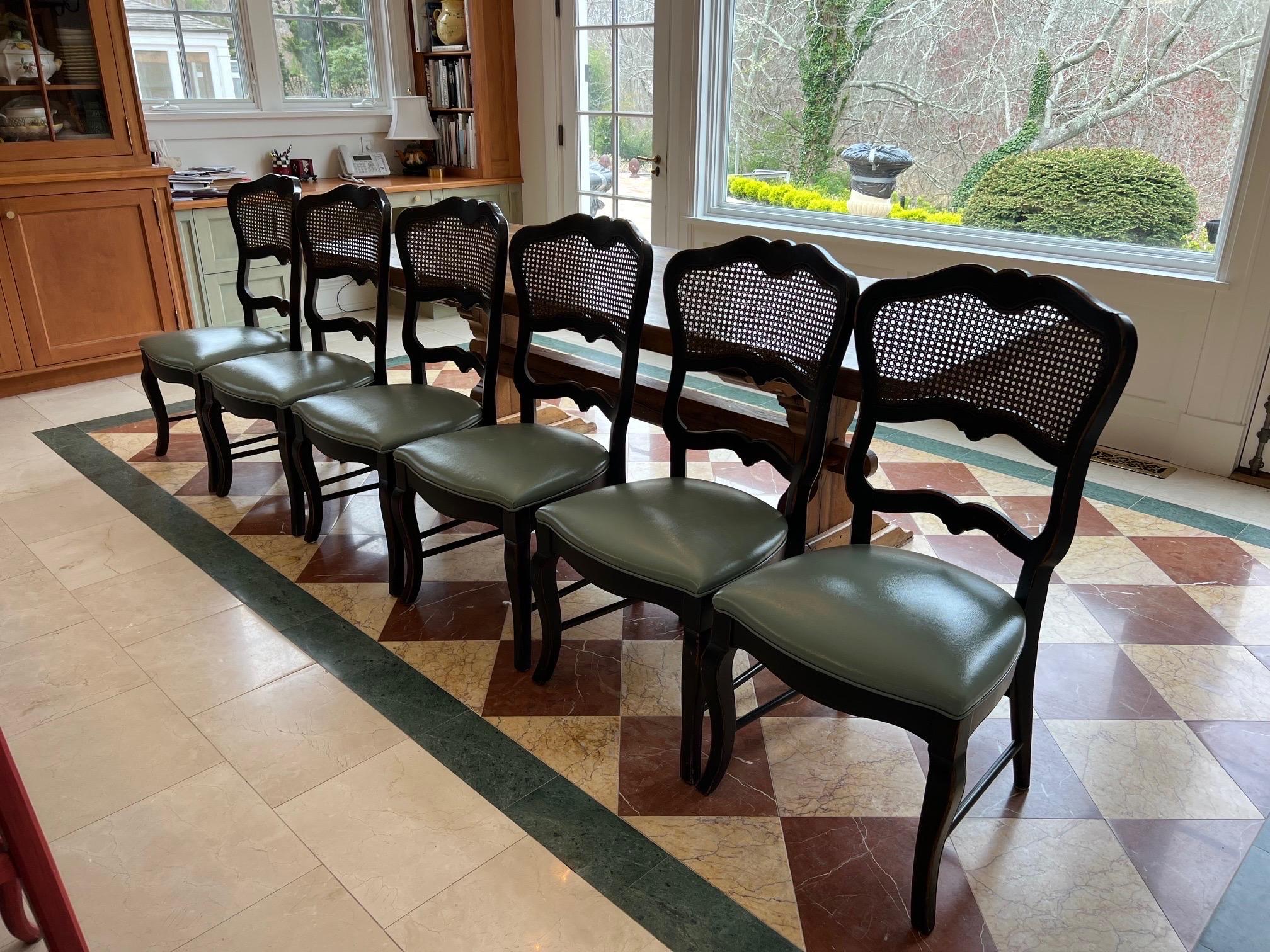 Set di otto sedie da pranzo in stile provinciale francese con canne nere
Due poltrone e 6 sedie laterali sono ben realizzate in legno massiccio, probabilmente noce o legno di frutta, con una finitura calda e marrone rossastra; sono caratterizzate da