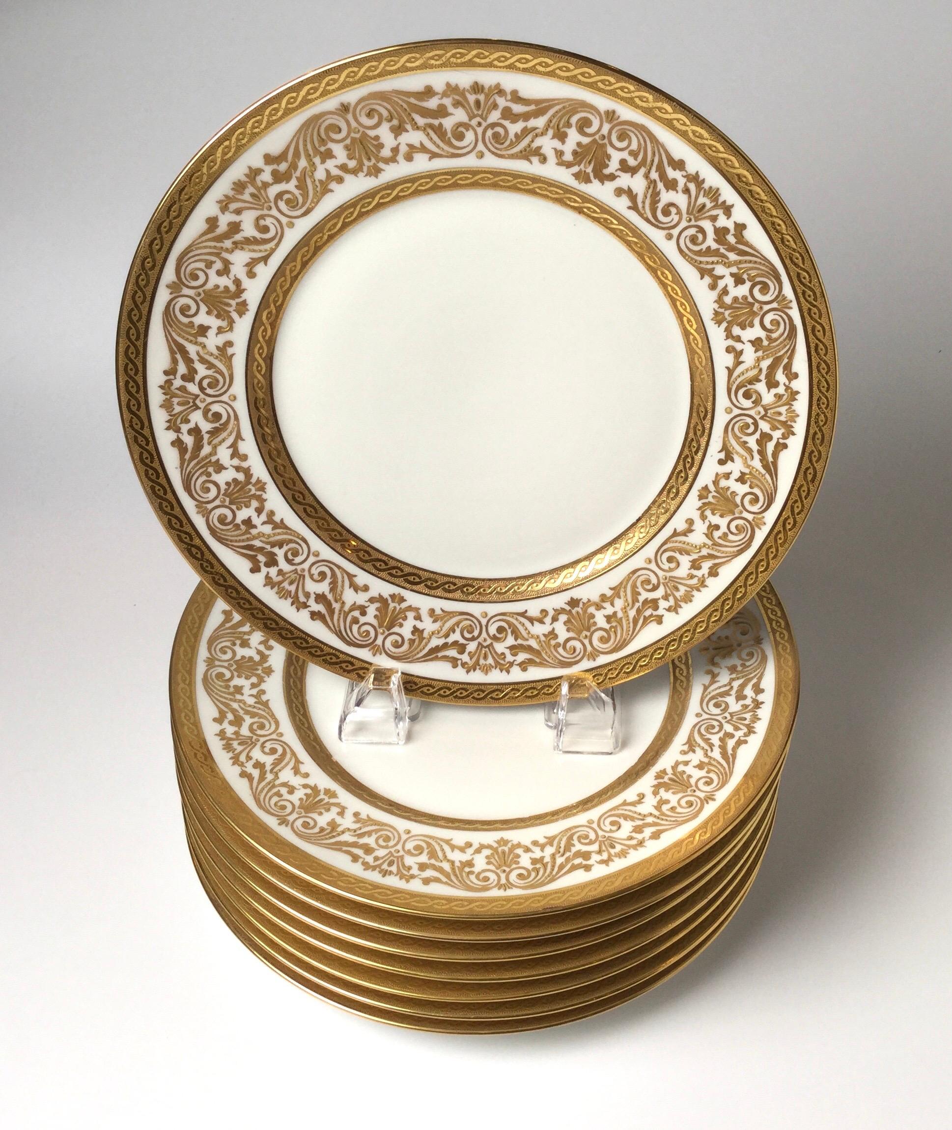 Elegant set of eight raised gilt border luncheon plates marked France, Bernardaud and Co. Limoges, circa 1900. The cream white porcelain hand decorated with lacy gold decoration.