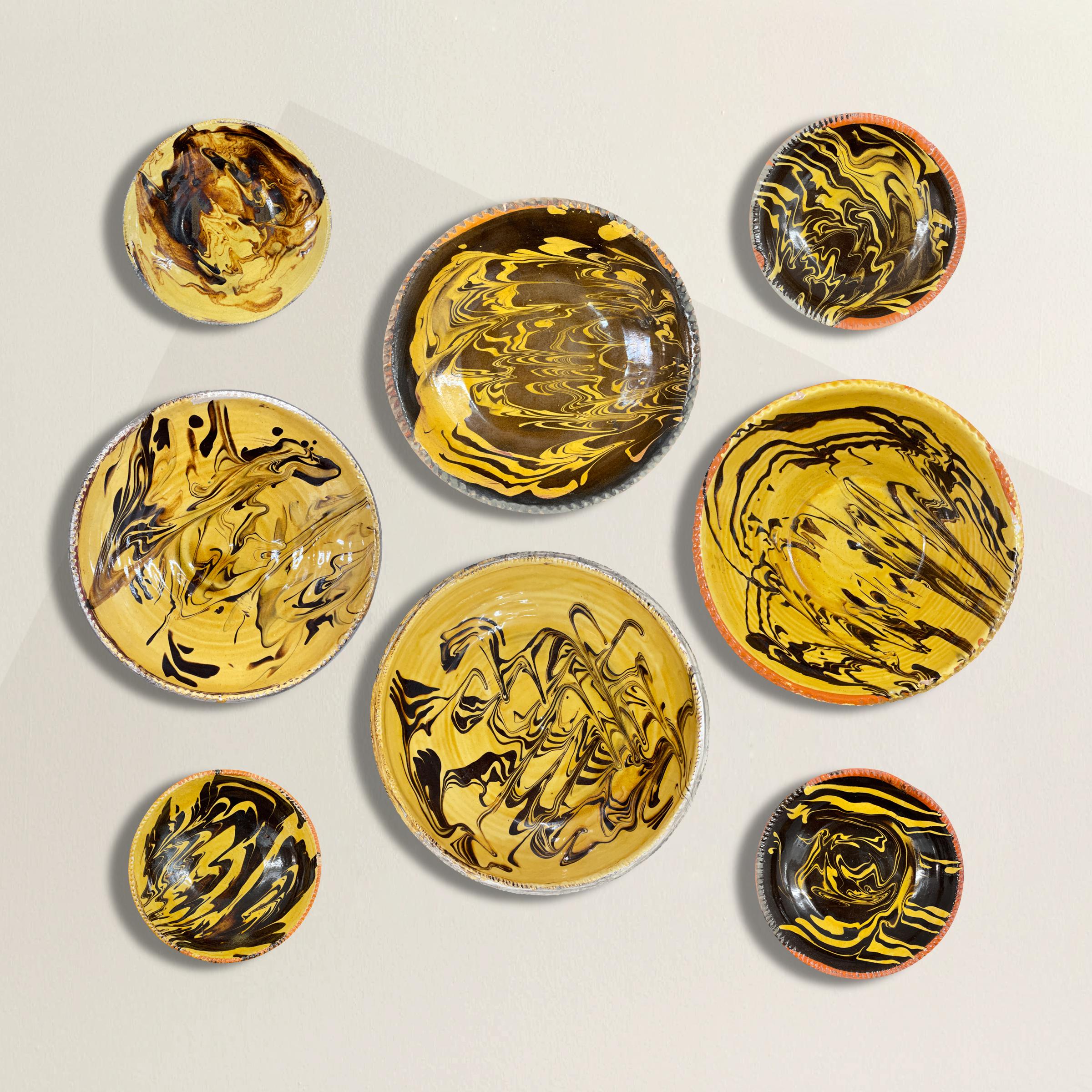 A striking set of eight 20th century French gold and brown swirl glazed terracotta bowls, and each with a custom steel wall mount so you can hang in your kitchen, pantry, dining room, or anywhere else you desire. 

Largest: 11 in. diameter x 2.5
