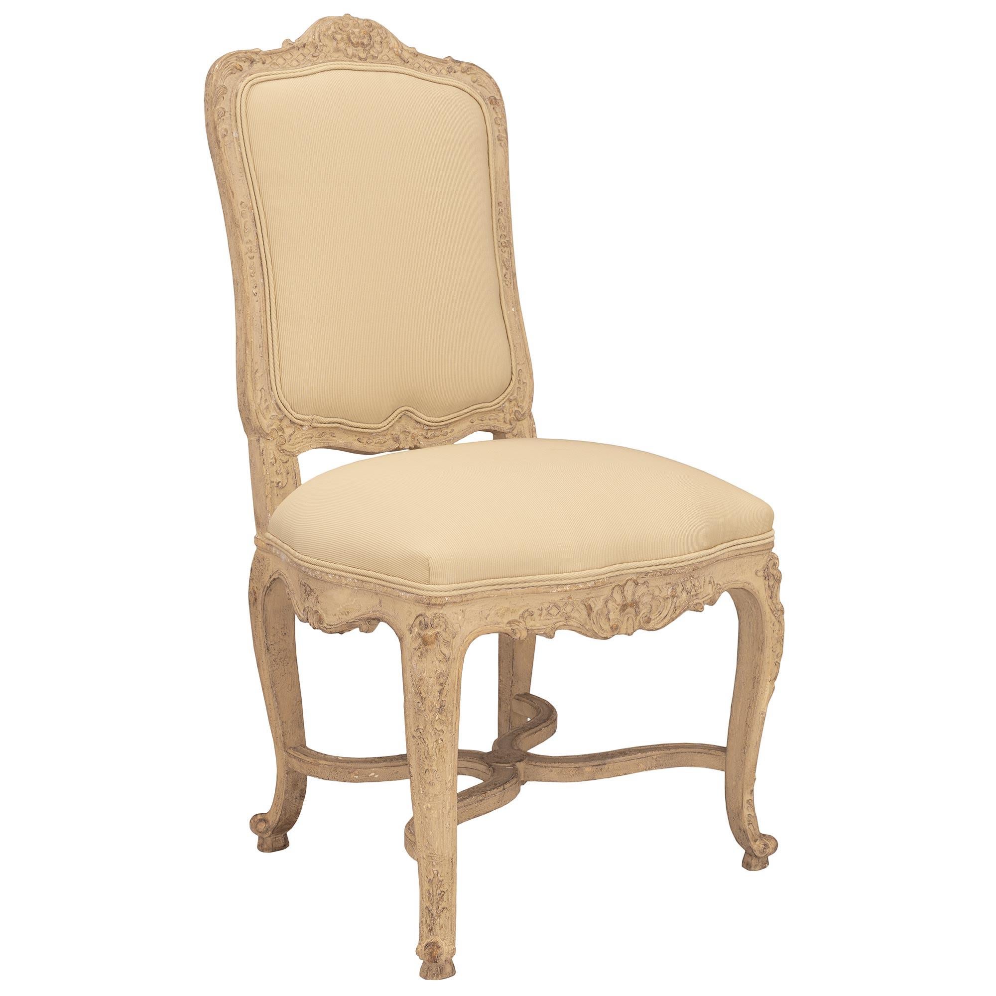 A charming and very high quality set of eight French turn-of-the-century Louis XV st. patinated dining chairs. Each chair is raised by elegant cabriole legs with fine scrolled feet, richly carved acanthus leaves and corner foliate designs. Each leg