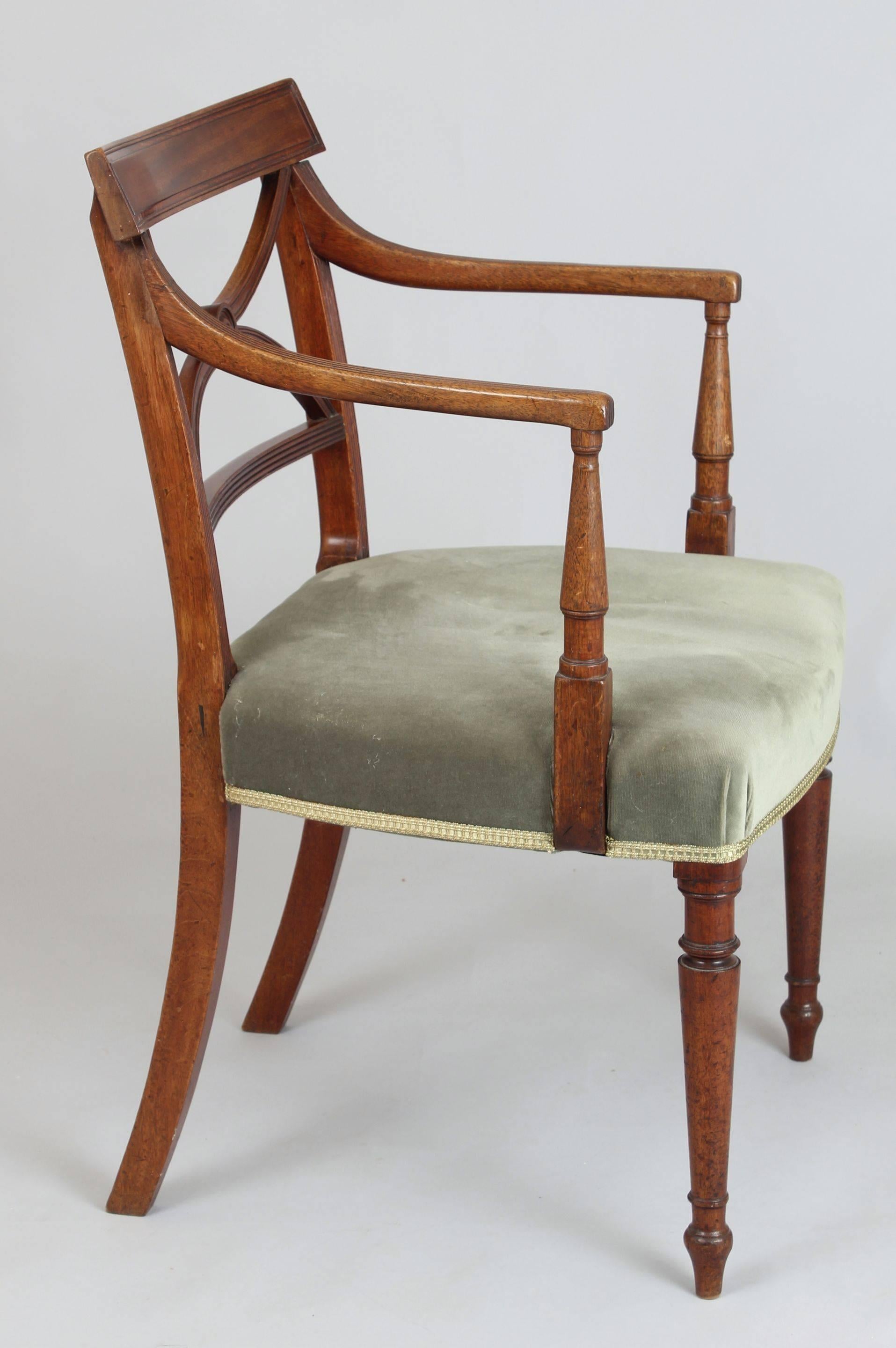 Set of eight George III period mahogany dining-chairs; six side-chairs and two elbow-chairs with reeded frames, X-shaped splats and overhanging top-panels; the stuff-over seats covered in green velvet and on turned legs.