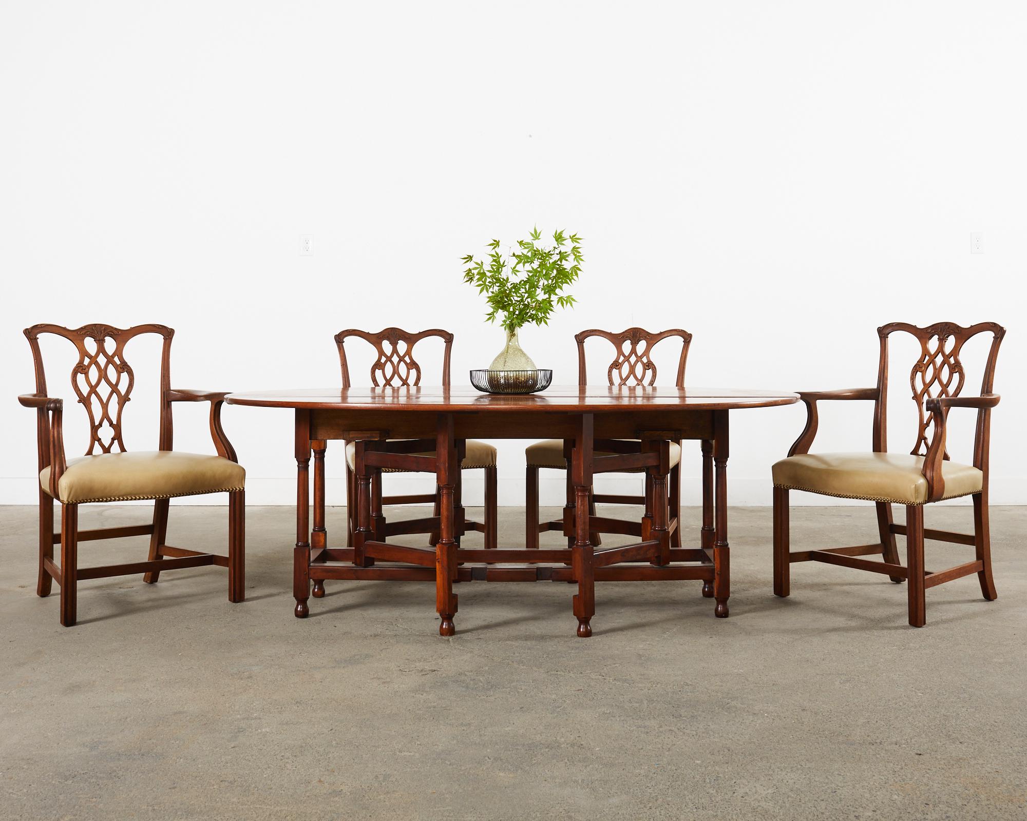 Gorgeous set of eight hand-carved mahogany dining chairs crafted in the English Georgian or Thomas Chippendale taste. The set consists of six side chairs and two host armchairs measuring 26.5 inches wide. The chairs have a dramatic bow shaped crest