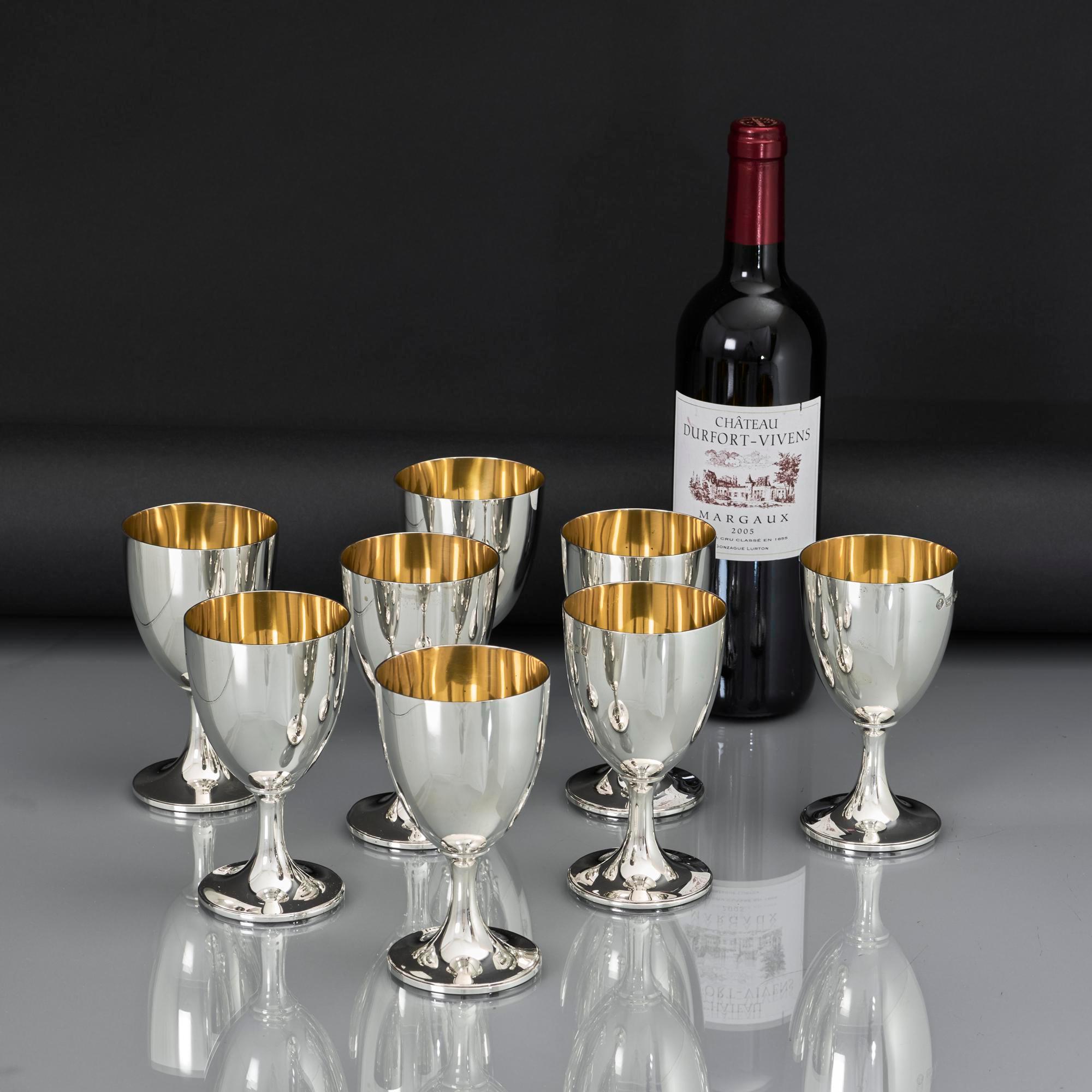 Set di otto calici d'argento del XX secolo creati in stile George III e caratterizzati da corpi rotondi semplici e lisci su basi circolari sporgenti. L'interno di ogni calice è ben dorato e la semplicità di questi calici d'argento si presta a essere