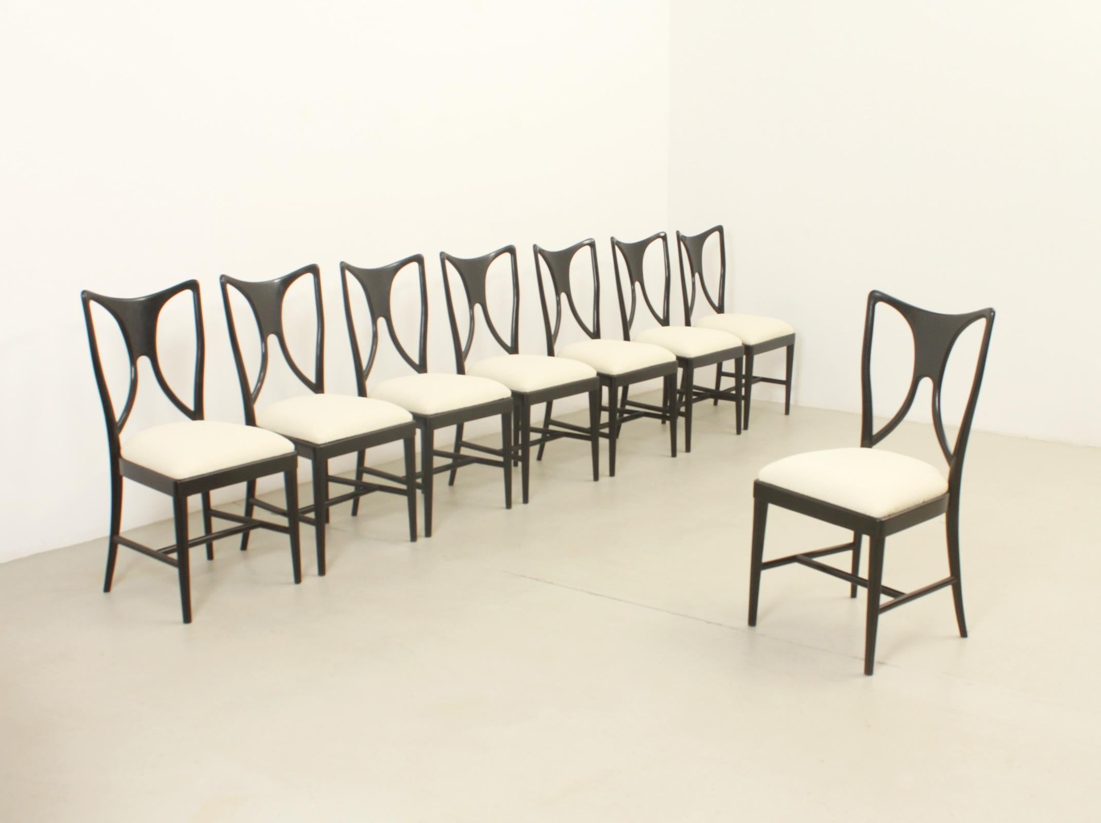 Ensemble de huit chaises attribuées à Guglielmo Ulrich, Italie, années 1940. Structure en bois de noyer ébonisé et sièges rembourrés avec un nouveau tissu bouclé. 