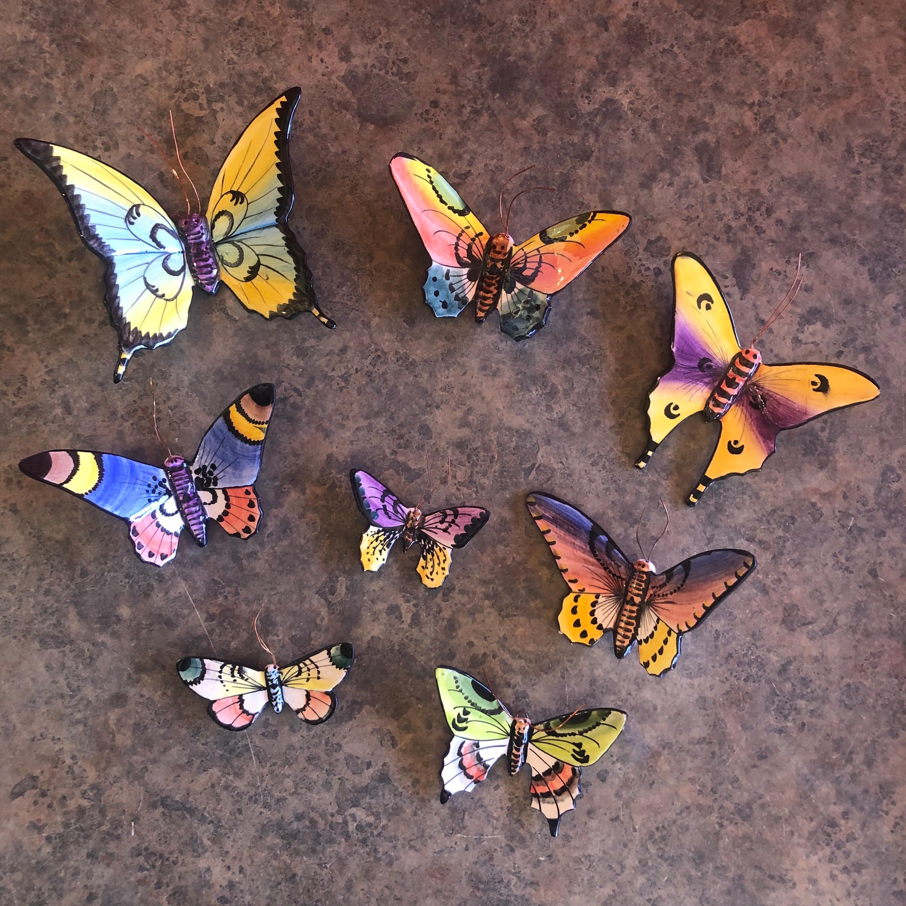 A very colorful set of eight handmade ceramic butterfly wall art from Portugal, circa 1990s. The butterflies are all hand painted and are various sizes from 2