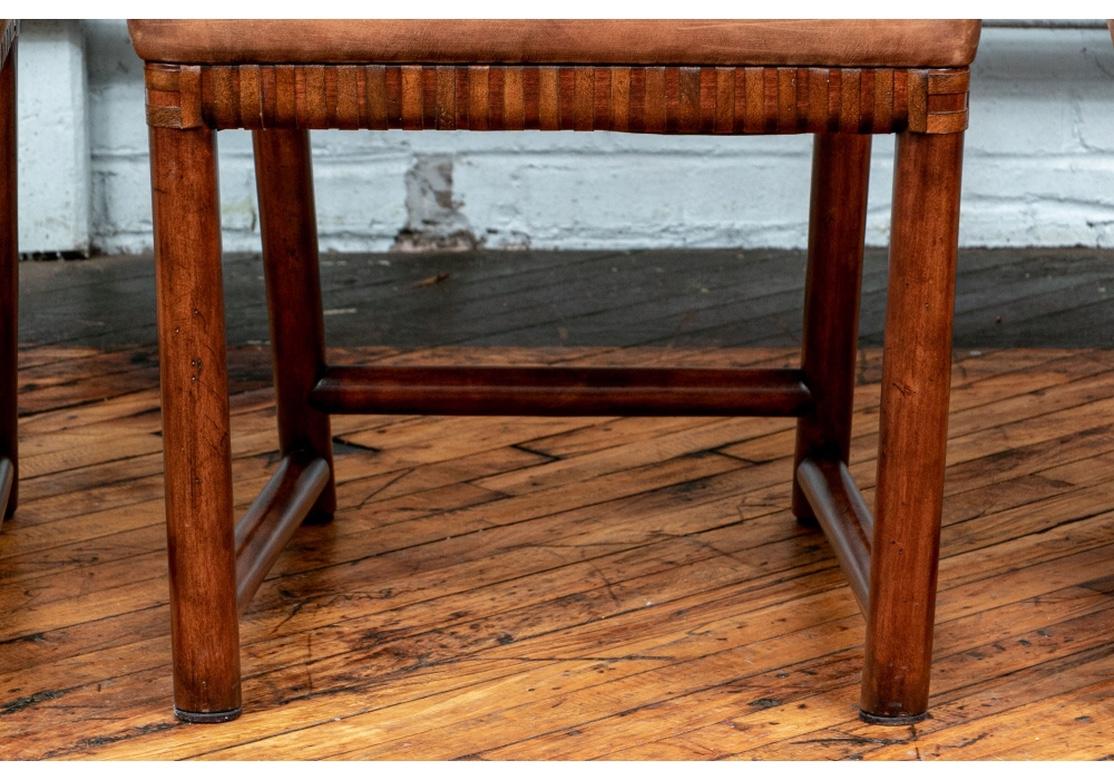 From Henredon’s, “Acquisitions” line. Finely crafted in mahogany frames with dark brown woven leather backs and seat skirts. The cylindrical wood crest rails with extended ends. Raised on cylindrical legs with side and back stretchers. The seats