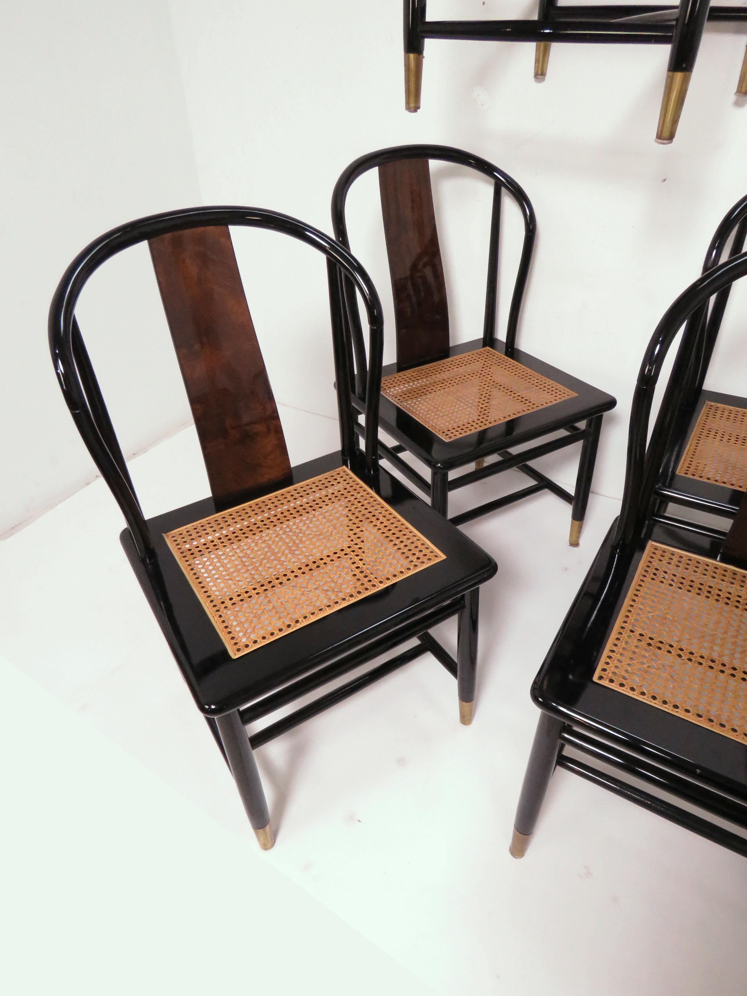 A set of eight dining chairs, consisting of six side chairs and two armchairs from Henredon’s Scene III Collection, circa 1980s. In black lacquer with burl walnut back accents, caned seat panels and brass ferrules, these were a modernist
