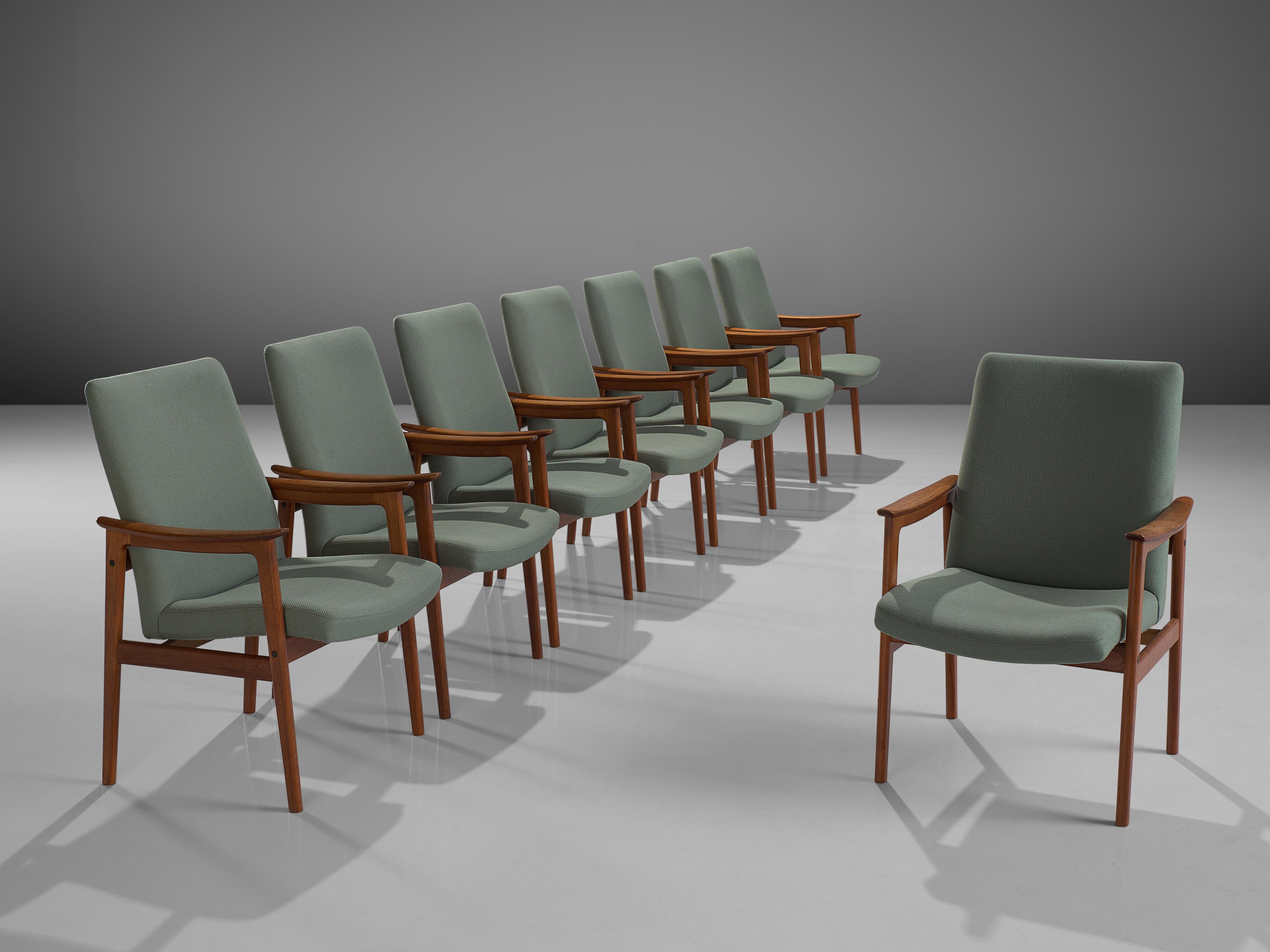 Set of eight armchairs, teak and mint green fabric, Scandinavia, 1950s. 

These Scandinavian teak dining chairs with armrests are both stately and modest. This set has an elegant teak frame with a beautiful visible grain. Nicely curved armrests and