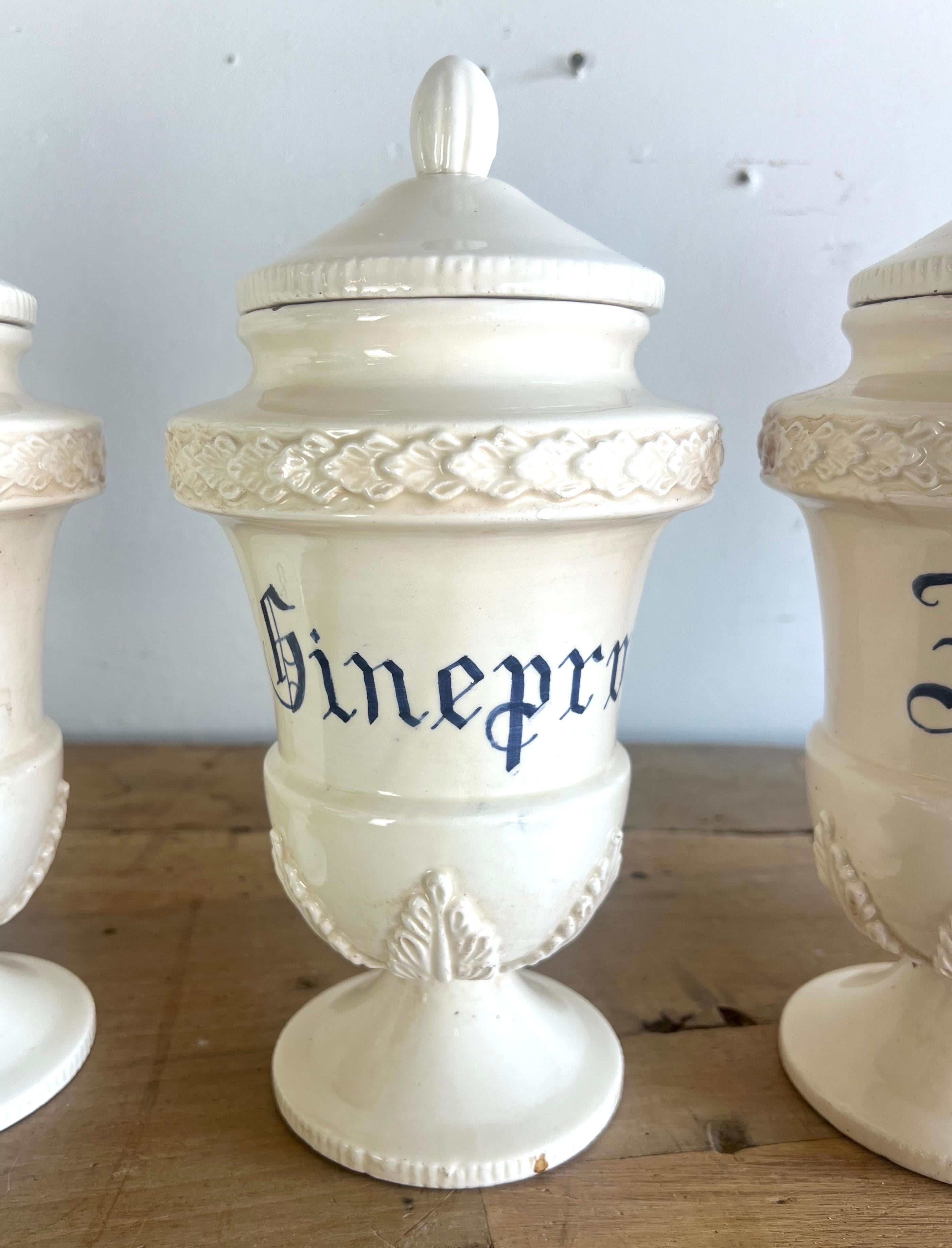 Set of eight Italian ceramic Apothecary Jars with lids.  Each cream colored jar has a spice name painted in a calligraphy style font.