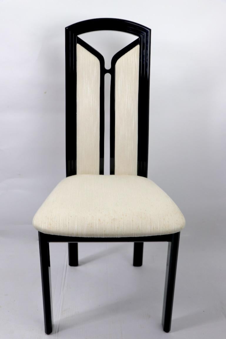 Stylish 1980s Art Deco Revival dining chairs Made in Italy, by Tonon.
Black lacquer frames with off white upholstered seats and back rests (A couple have stains).
Hard to find nice vintage sets of eight dining chairs, these are long on style and