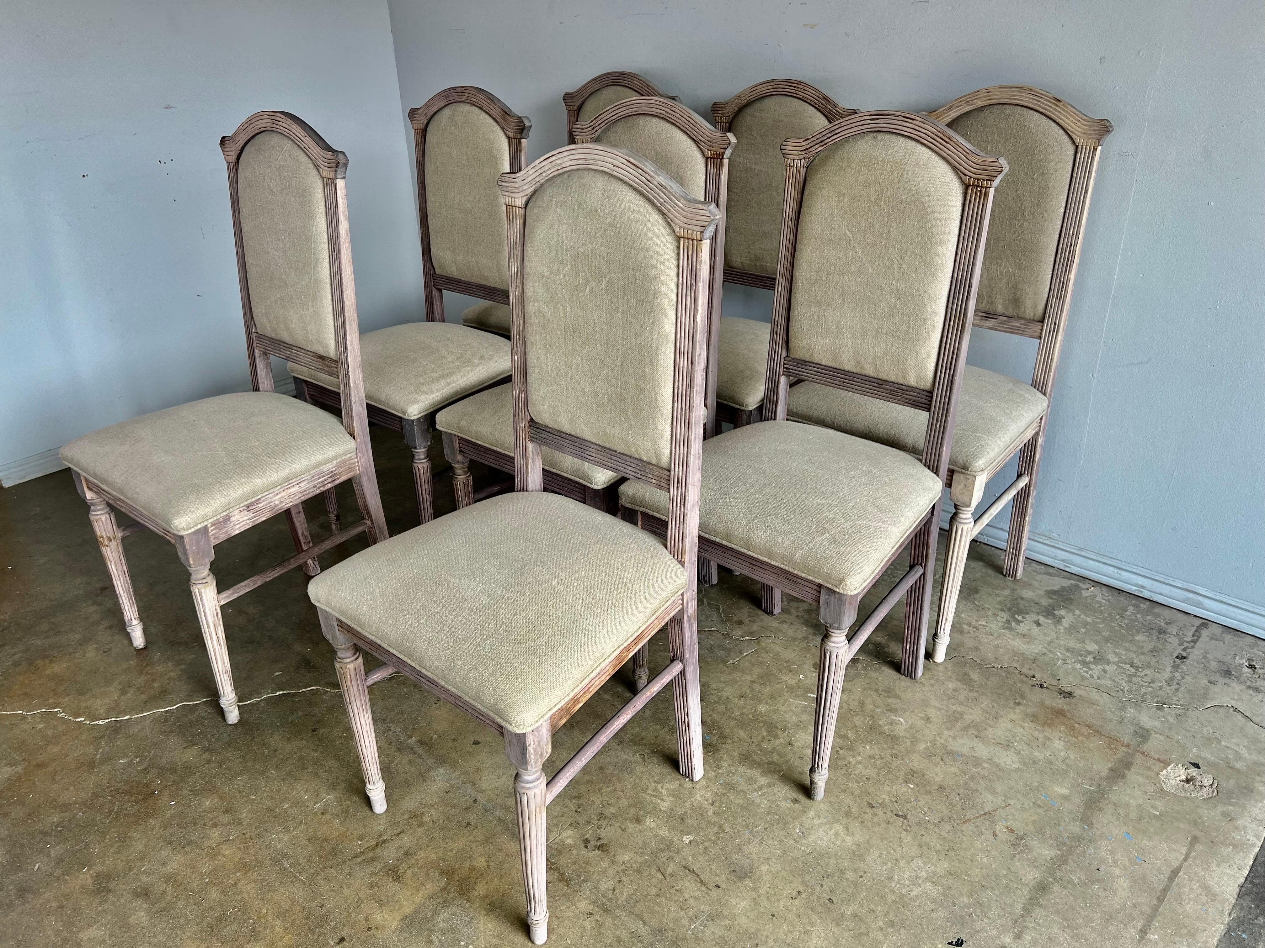 Set of eight bleached Italian Neoclassical style dining chairs. The chairs are newly upholstered in Belgium linen with a self cord detail.