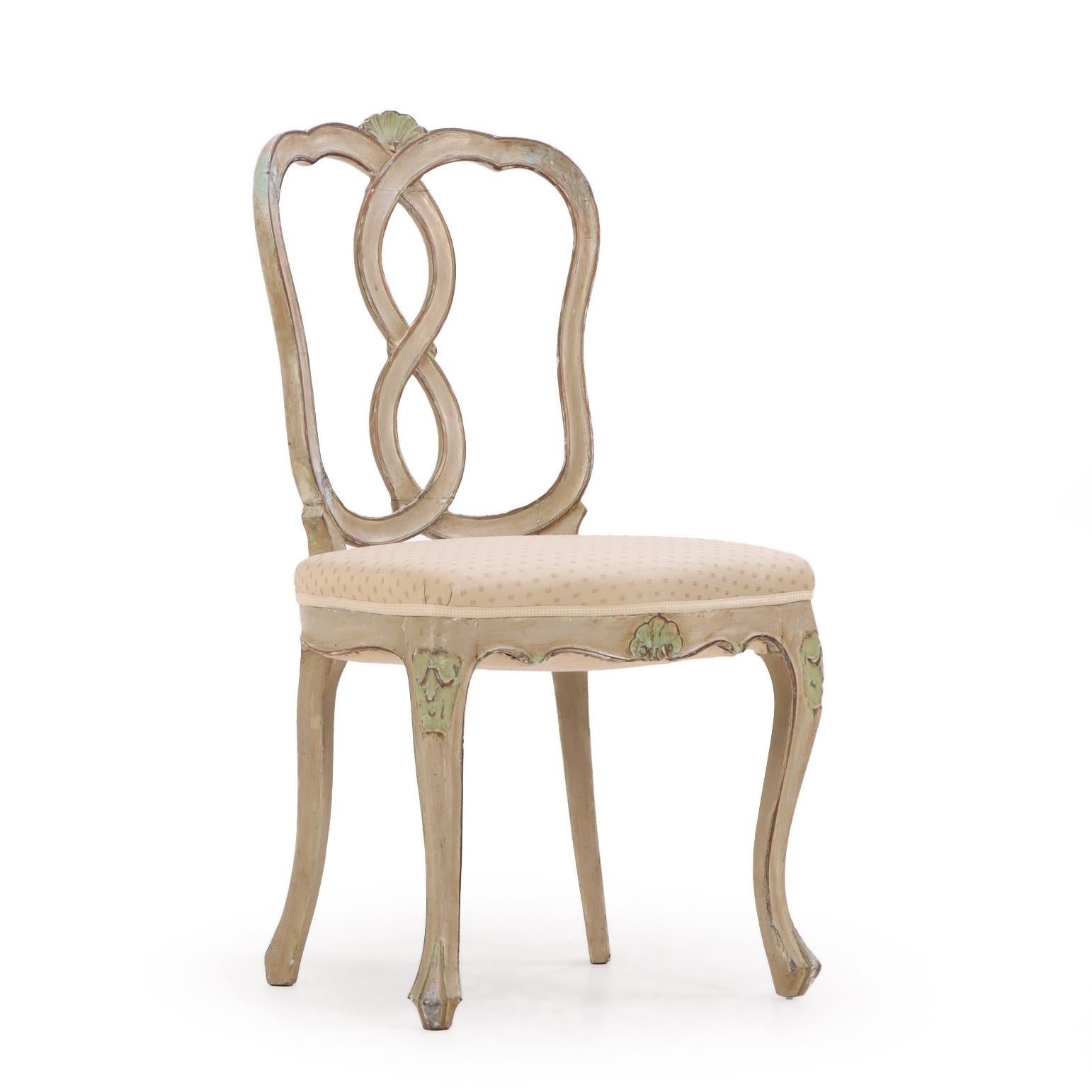 Chaque chaise d'appoint est dotée d'un dossier en forme de huit ouvert au-dessus d'une assise rembourrée, sur un tablier sculpté de coquillages et d'élégants pieds cabriole. Conservant des traces de la finition peinte, ces chaises présentent