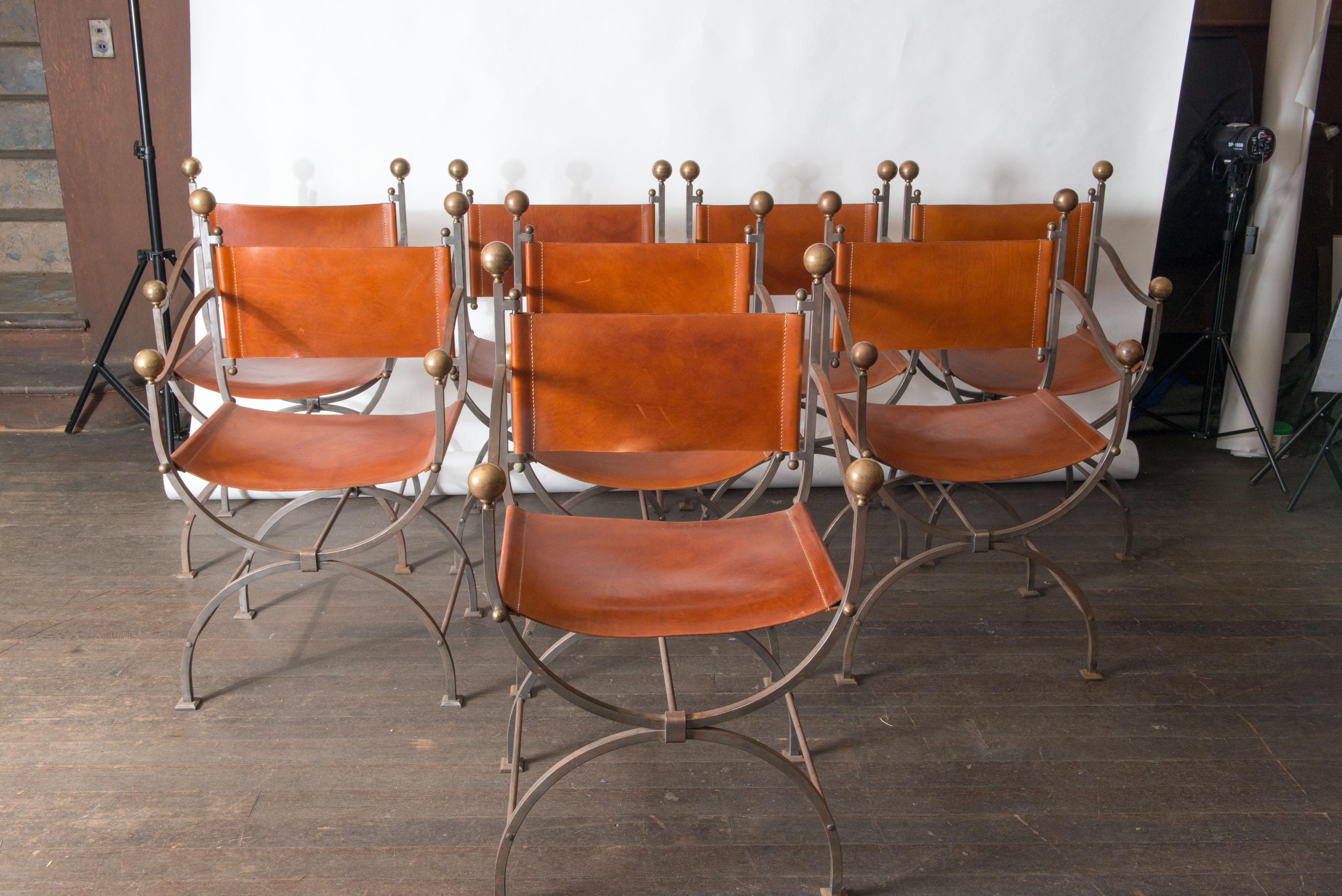 Set of 8 mid-20th century Italian Savonarola curule brass and steel armchairs with leather seat and back rest. They can be purchased as pairs for $4000. Each chair has four brass ball finials, and X-Form base. 
Created in Italy during the Midcentury