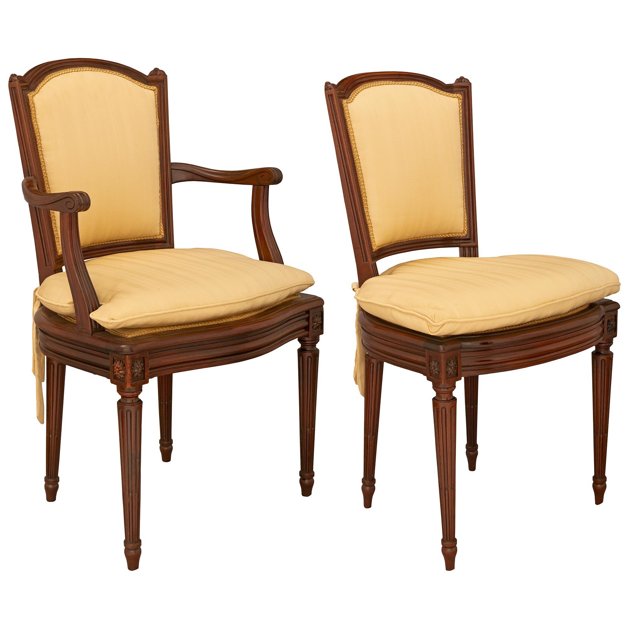 An attractive set of eight late 19th century Louis XVI st. mahogany dining chairs with six side and two armchairs. Each chair is raised on tapered fluted legs with top rosettes below a bombe shaped moulded frieze. Above is the curved and moulded