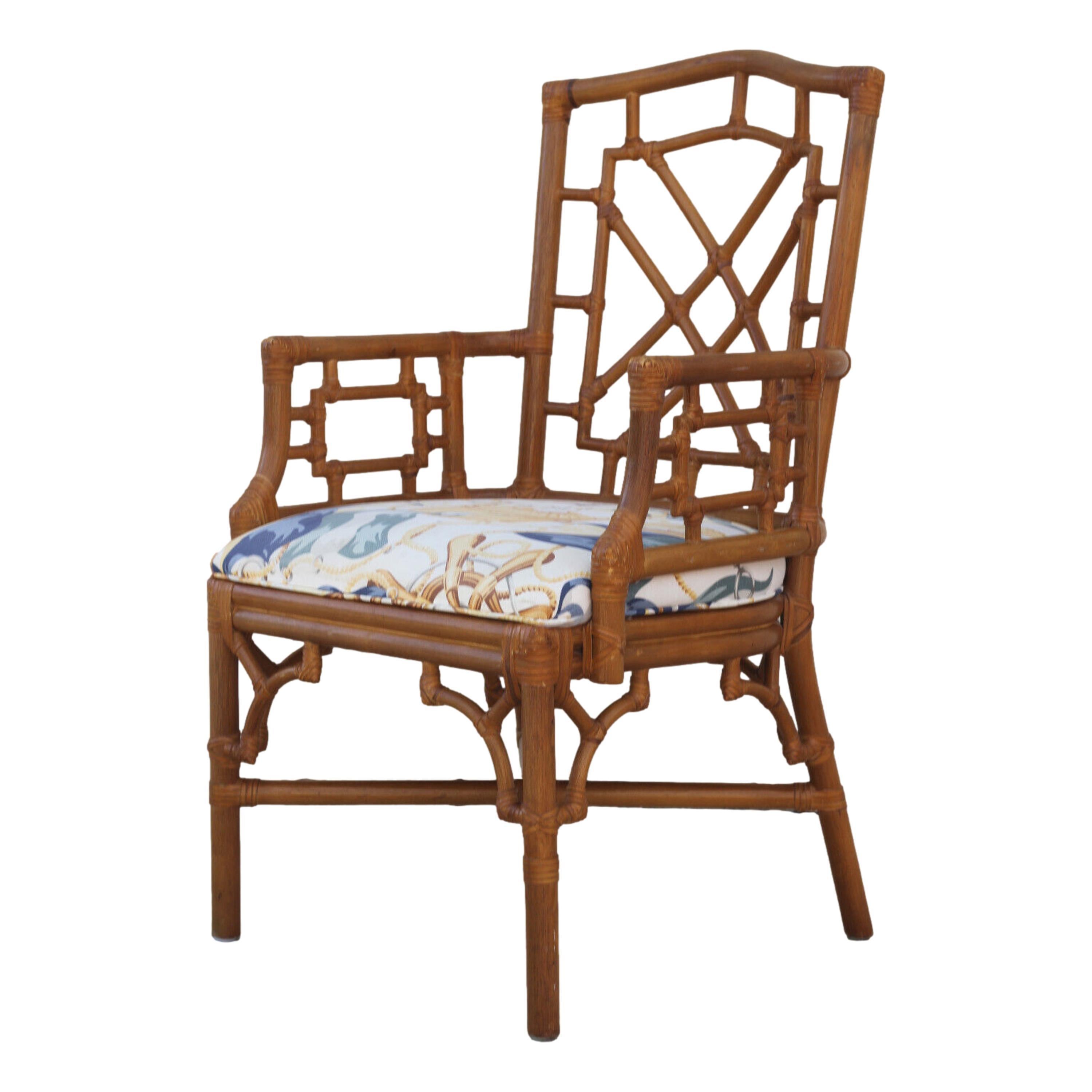 A lovely set of eight vintage rattan dining armchairs by Lexington. The Chinese Chippendale style chairs feature rattan frames with rattan fretwork on the chair backs, arm panels, and fretwork corners under the seats. Leather lacing is used on the
