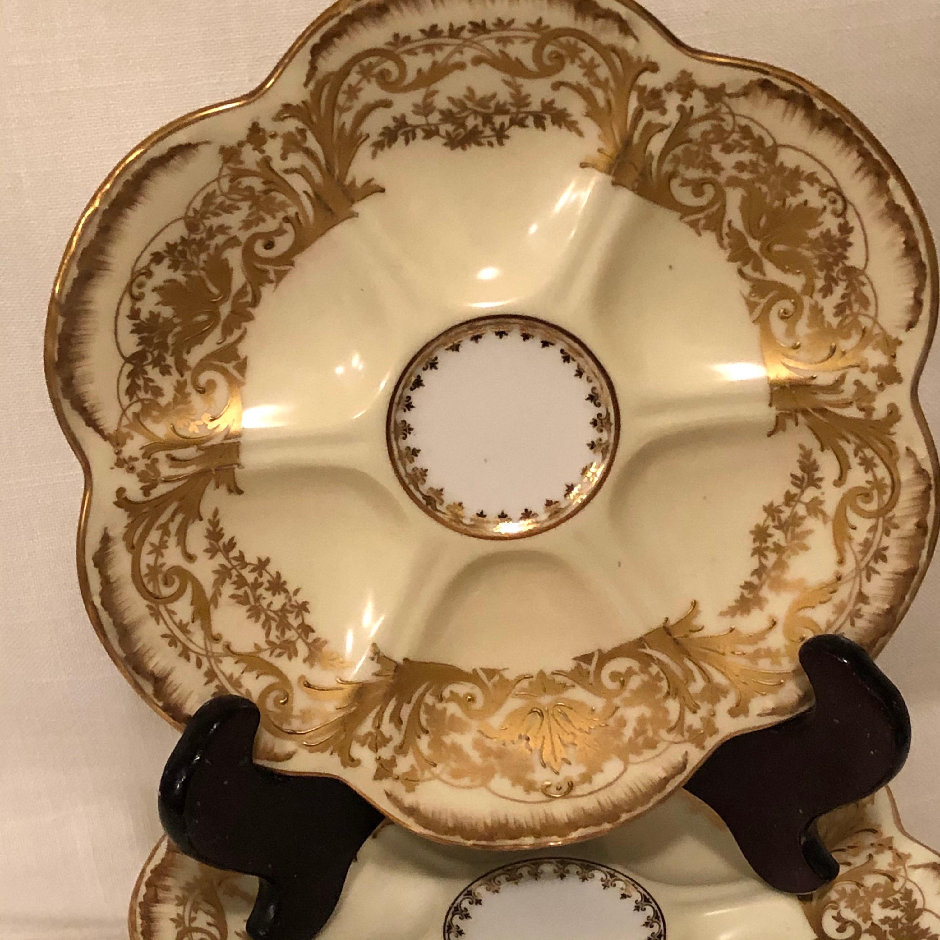 This is a beautiful set of eight Limoges, D& C, R. Delinieres and Co., oyster plates. Each oyster plate is decorated with profuse raised gilding. They are also signed L. Bernaudaud & Co. on the back. They have six wells around the plate and one well